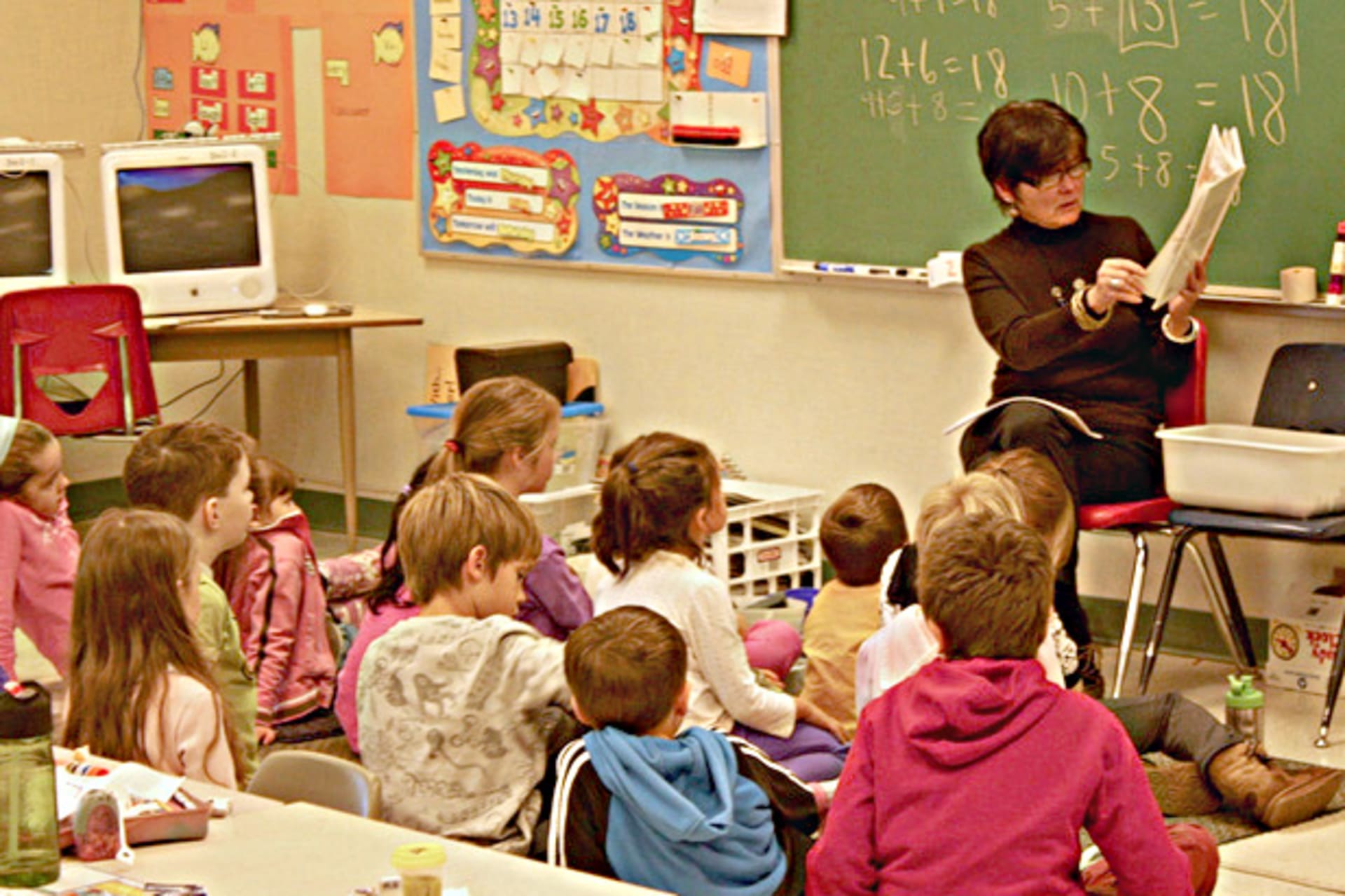 <p>A teacher reads to first grade students (gibsonsgolfer/flickr).</p>
