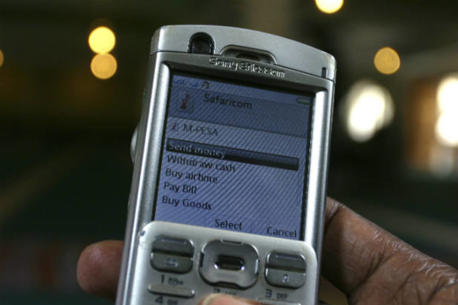 <p>A man scrolls through his mobile phone to carry out a transaction via M-Pesa in Nairobi, Kenya on May 12, 2009 (Noor Khamis/Courtesy Reuters).</p>
