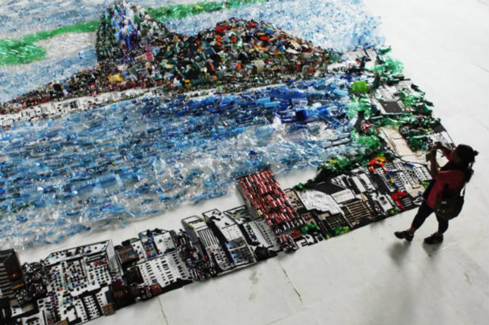 <p>A woman takes a picture of an image of Guanabara Bay made of recycled trash, part of an installation by Brazilian plastic artist Vik Muniz, during the Rio+20 Conference on June 22, 2012 (Nacho Doce/Courtesy Reuters).</p>
