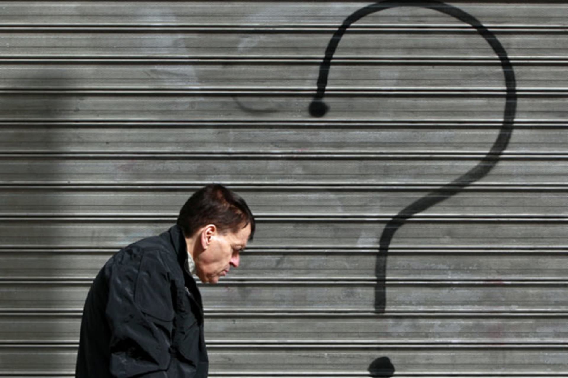 <p>A man walks in front of a closed bank branch in central Athens, February 2012 (John Kolesidis/Courtesy Reuters).</p>
