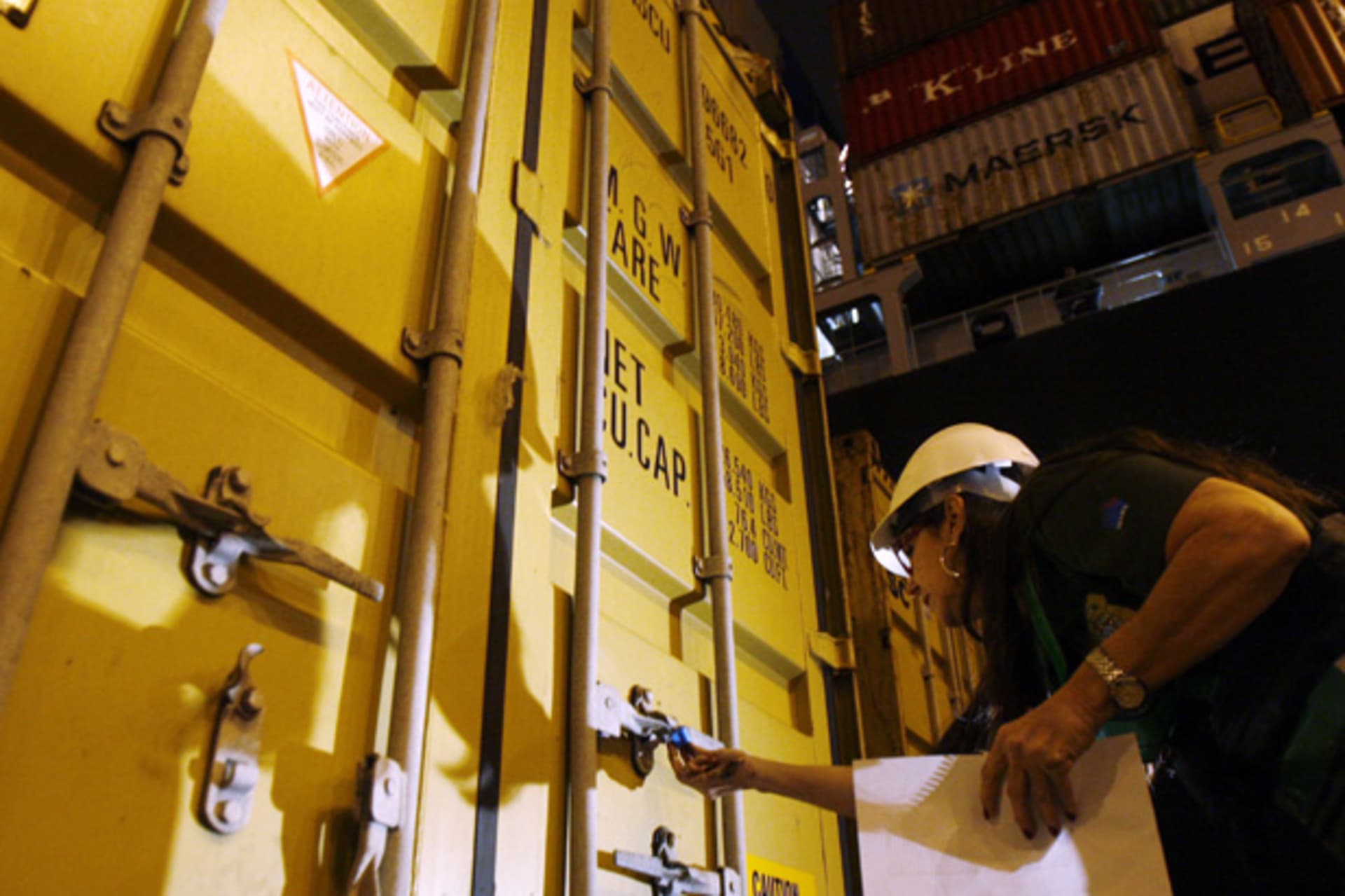 <p>An agent inspects a container filled with rubbish from Britain before it is loaded onto a ship at the port of Santos (Paulo Whitaker/Courtesy Reuters).</p>
