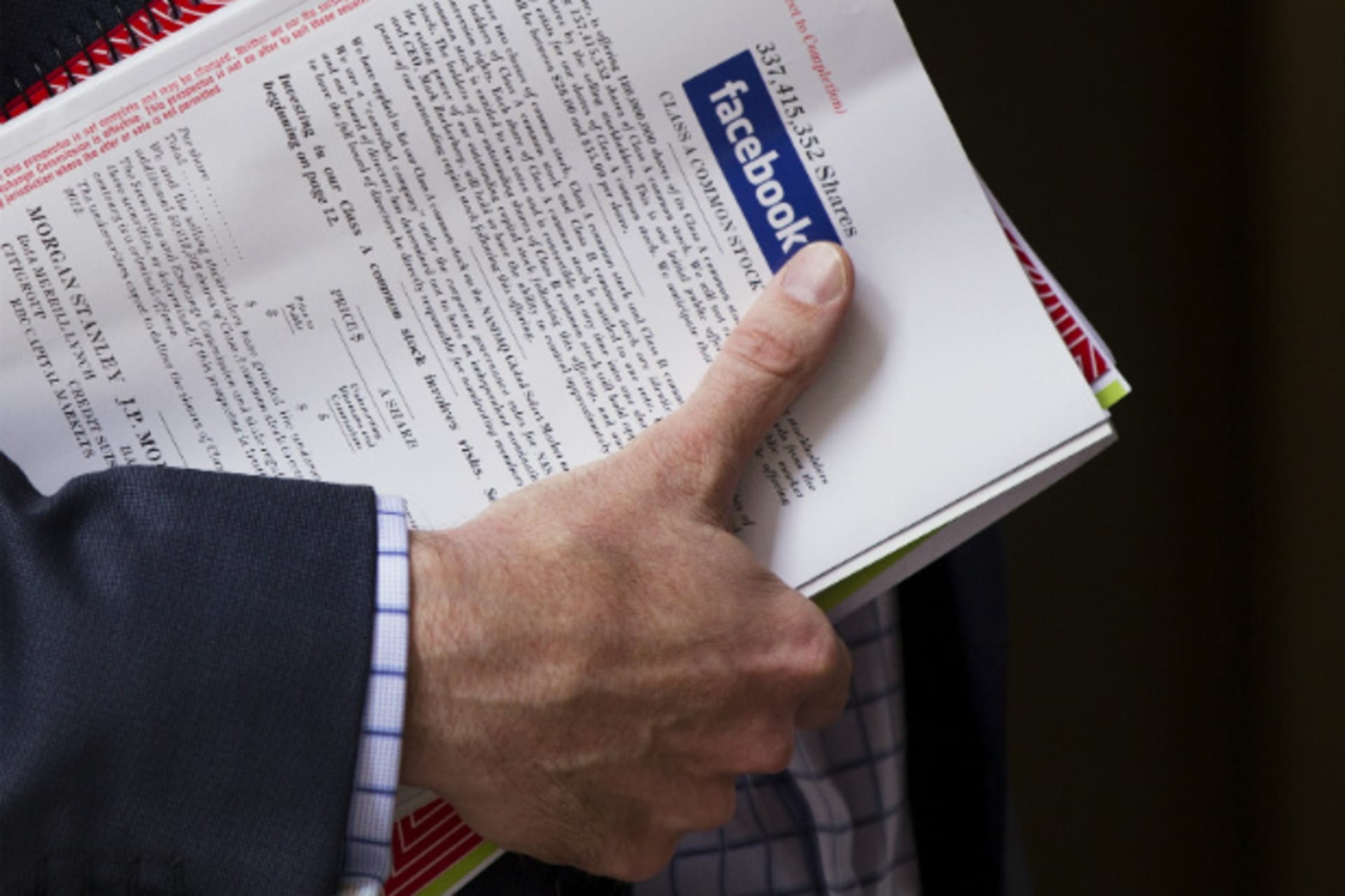<p>A man in New York holds a pamphlet of information on investing in Facebook’s IPO. (Lucas Jackson/Courtesy Reuters).</p>
