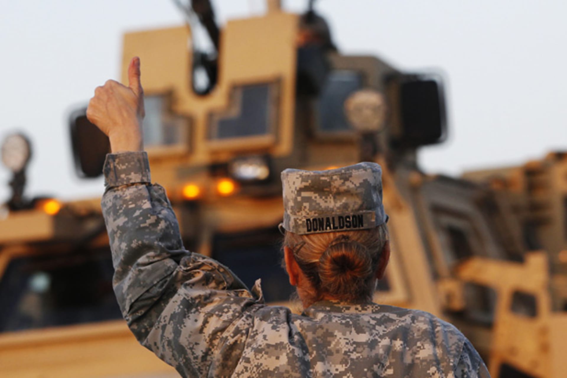 U.S. Army convoys are given the thumbs up from a fellow soldier after crossing into Kuwait during the last convoy out of Iraq