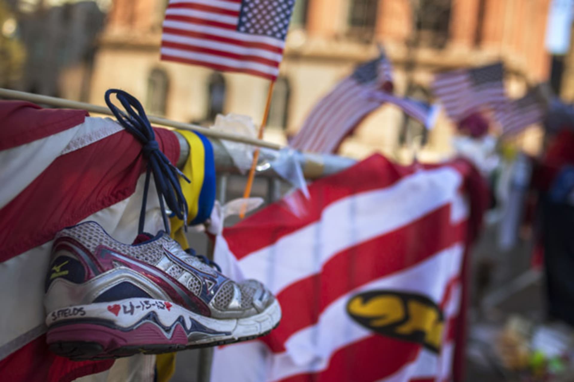 <p>A jogging shoe hangs at a makeshift memorial for the victims of the Boston Marathon bombings on Boylston Street (Shannon Stapleton/Courtesy Reuters).</p>