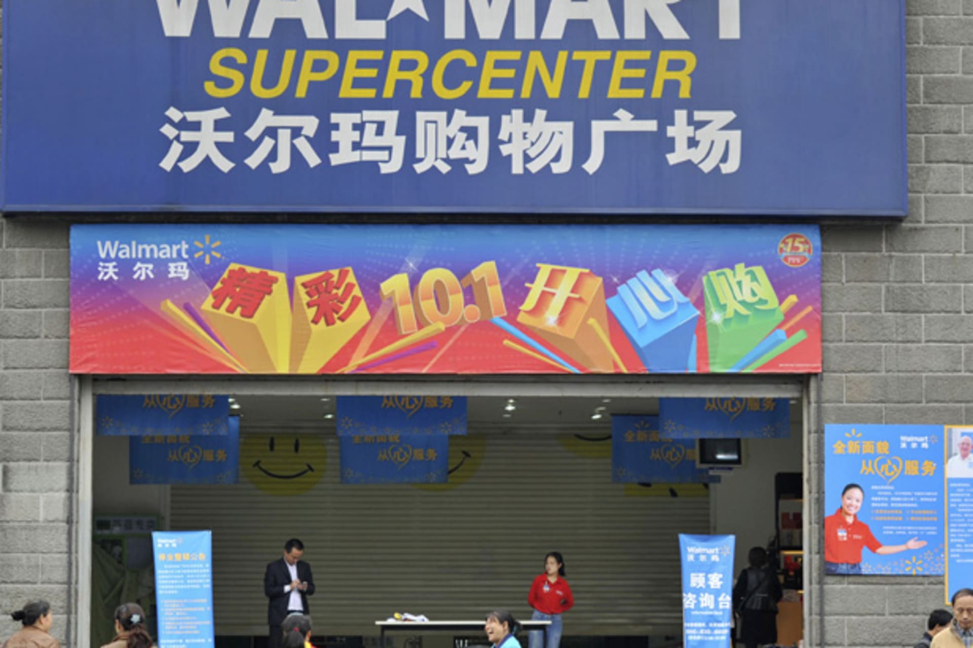 <p>Employees stand in front of the gate to a Wal-Mart Supercenter in Chongqing municipality, China. (Stringer/Courtesy Reuters)</p>
