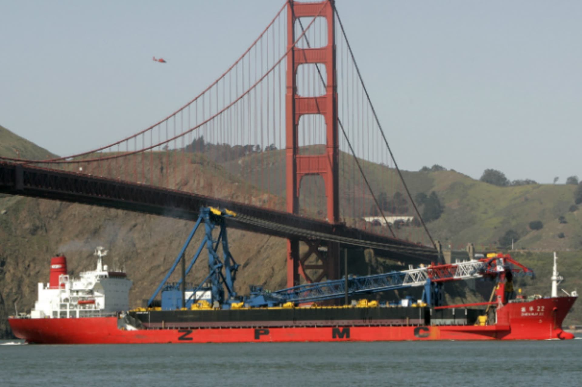 <p>A ship-borne 300-foot crane positions itself for a Golden Gate Bridge construction project in March 2009. (Robert Galbraith/Courtesy Reuters)</p>
