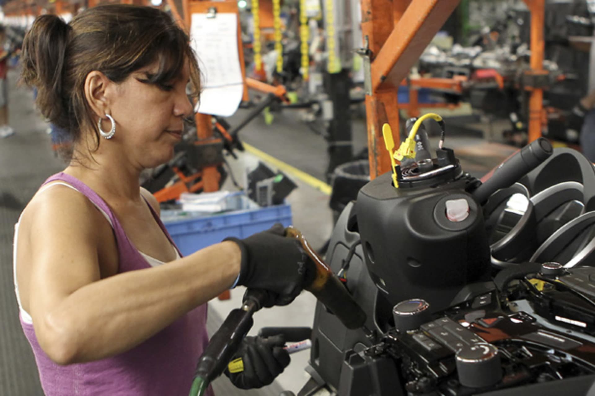<p>A worker installs parts onto the dashboard for a new car as it moves along the assembly line at a General Motors assembly plant in Lordstown, Ohio (Aaron Josefczy/Courtesy Reuters).</p>
