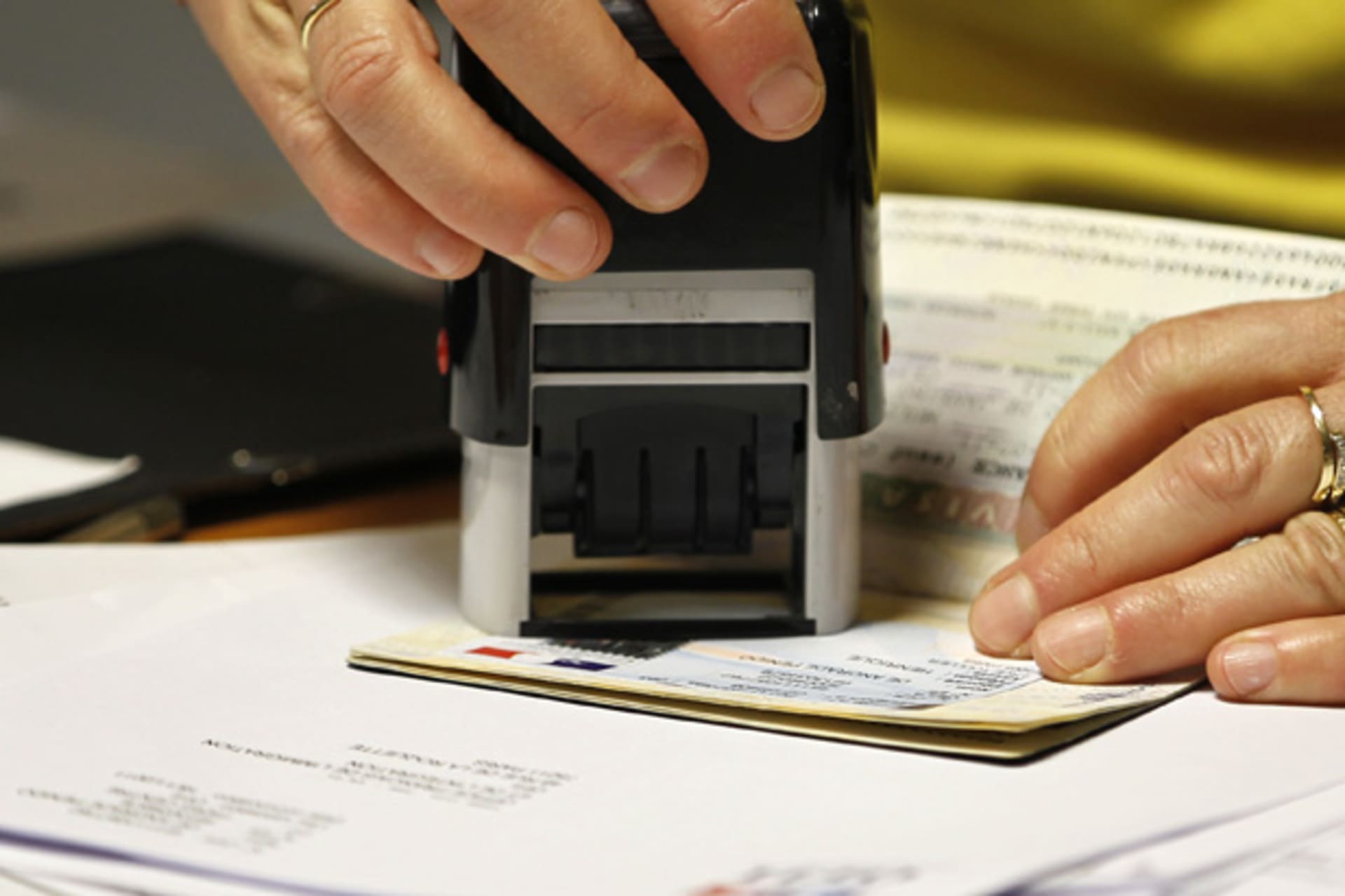 <p>An officer validates a visa on a student’s passport (Charles Platiau/Courtesy Reuters).</p>
