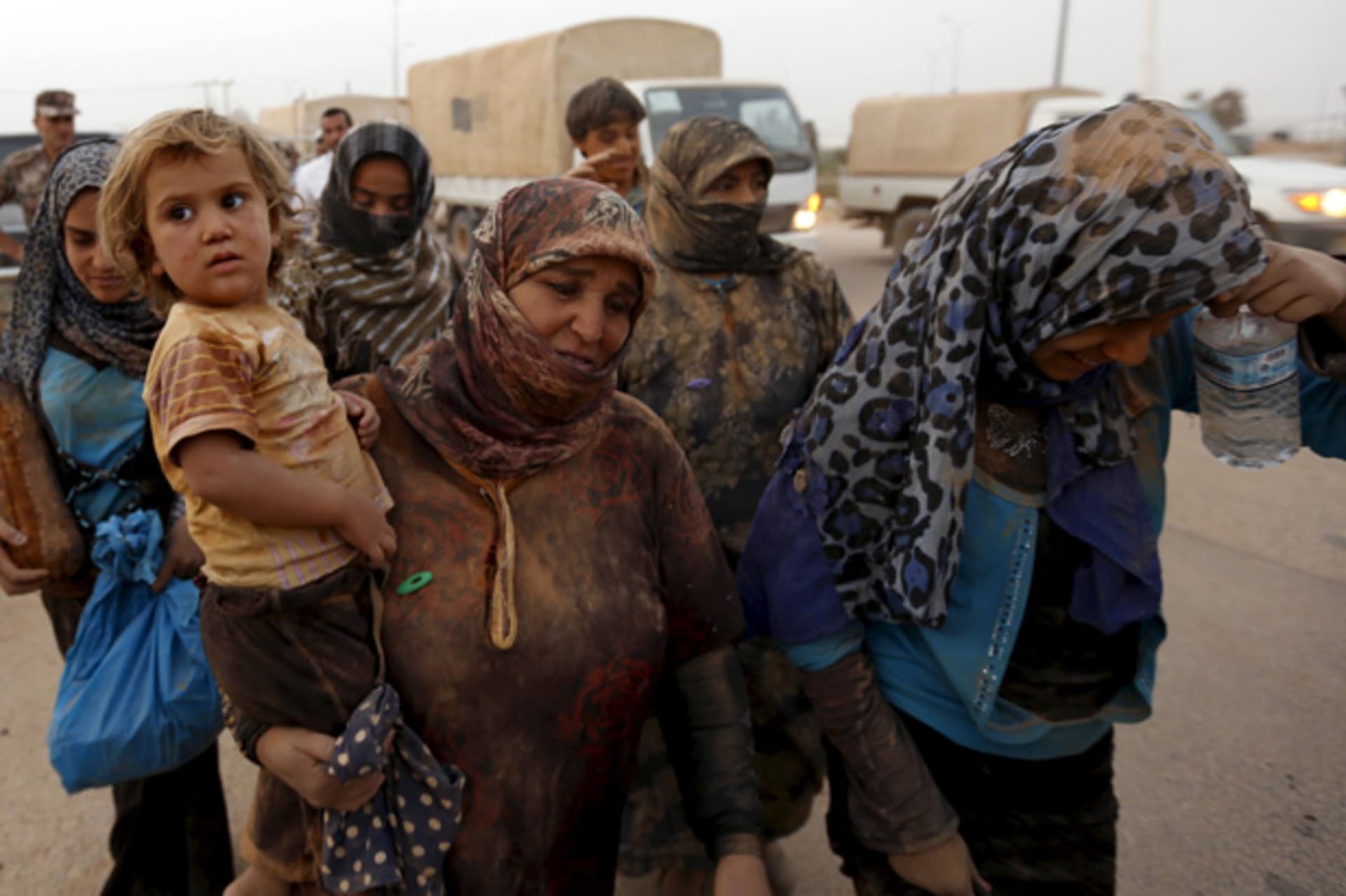 Syrian refugees covered with dust arrive at the Trabeel border