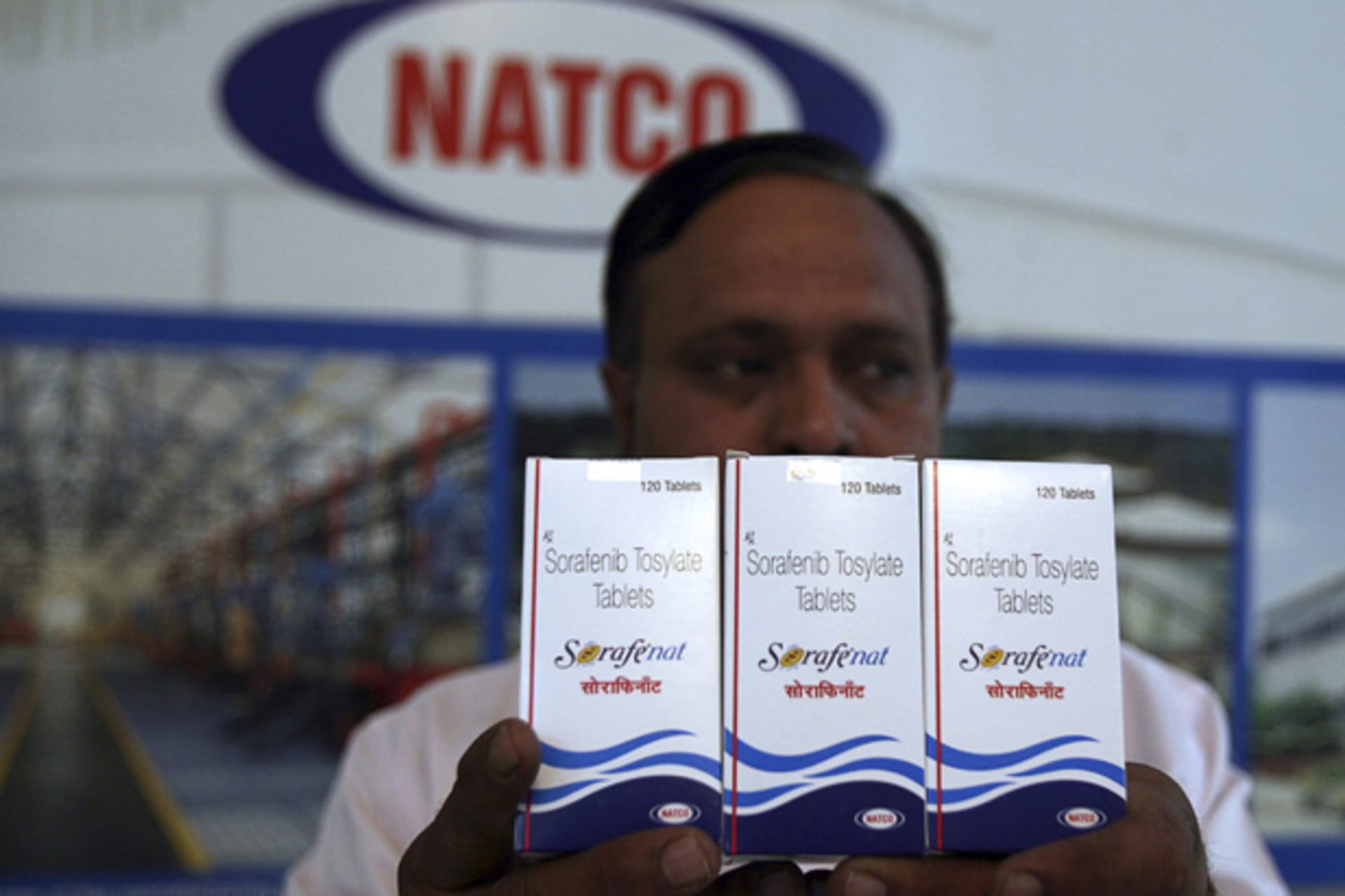 An official poses with packets of Sorafenib Tosylate tablets inside the head office of Natco in Hyderabad