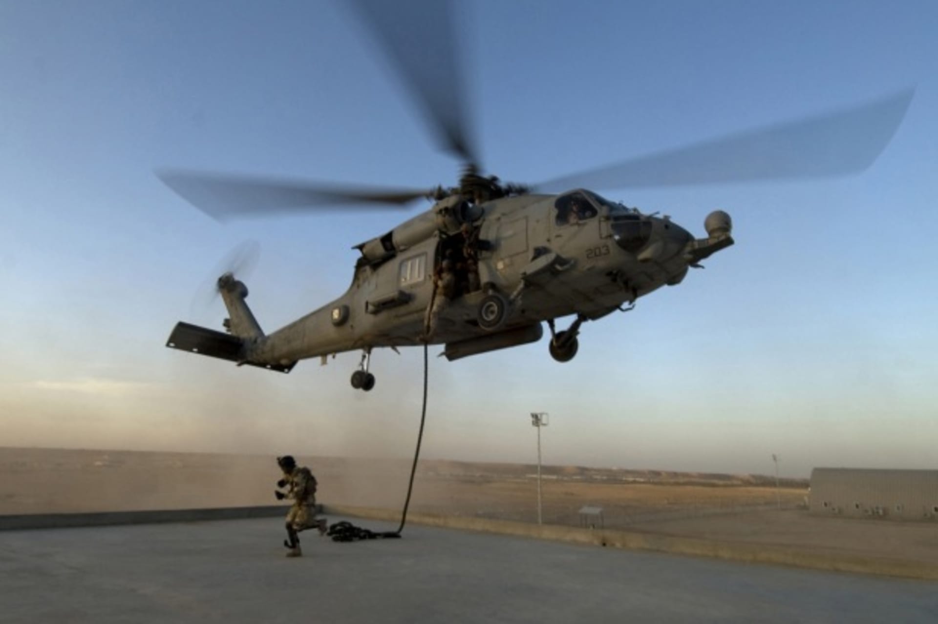 <p>A special operations soldier hustles to his position on the roof of a training building during a fast rope training exercise.</p>
