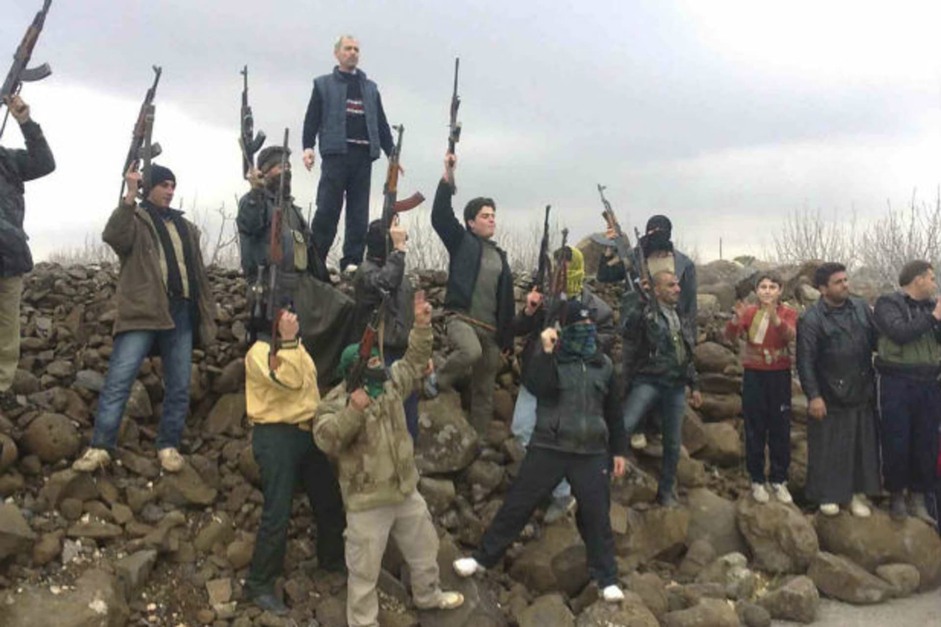 Syrian soldiers who defected to join the Free Syrian Army are seen among demonstrators during a protest against Syria's president Bashar al-Assad in Kafranbel near Idlib on January 29, 2012 (Courtesy Reuters).
