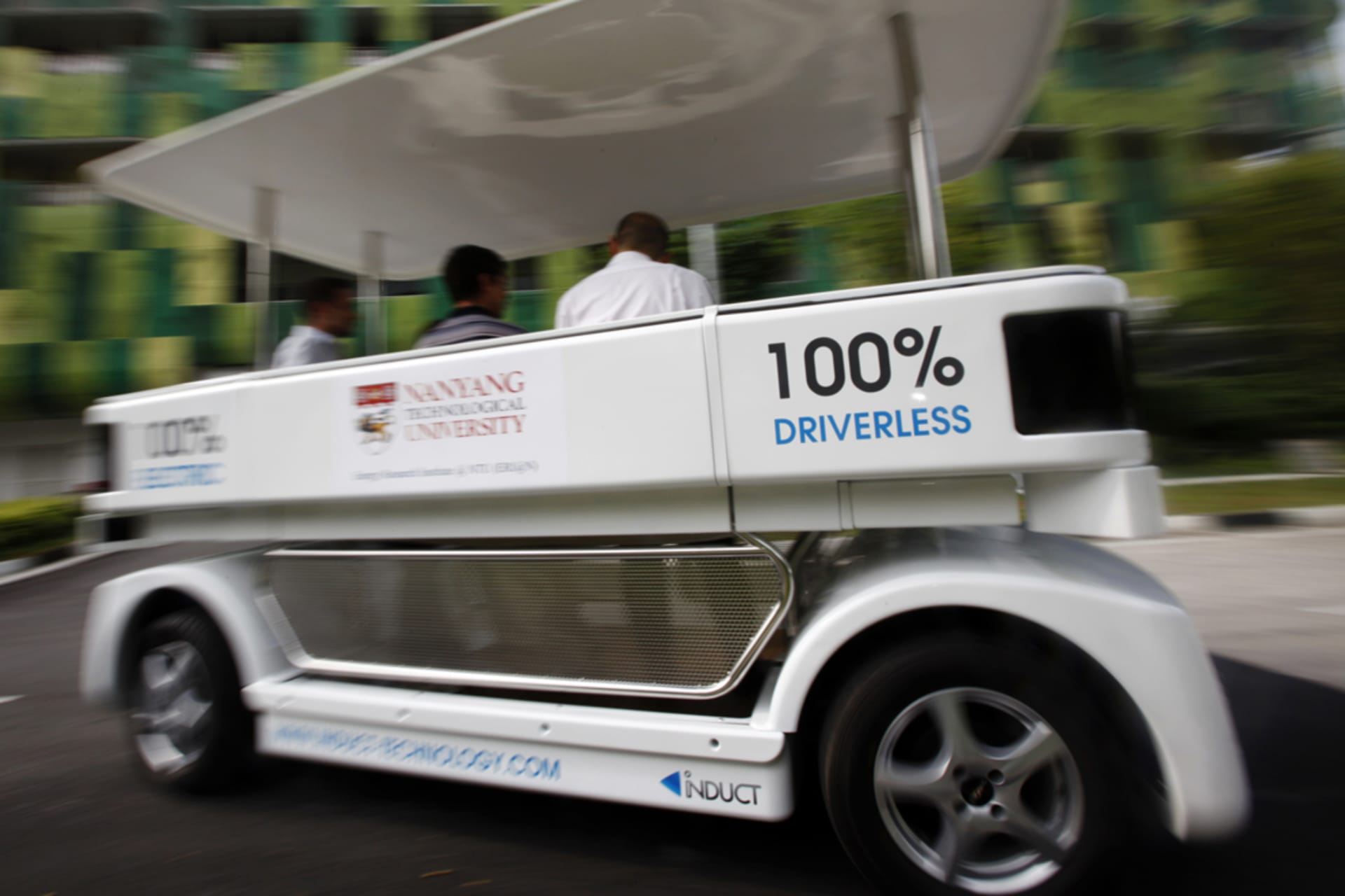 <p>People ride on a driverless electric vehicle at the Nanyang Technological University (NTU) in Singapore.</p>
