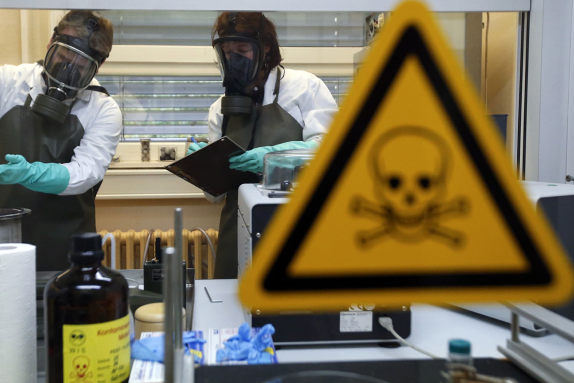 <p>German researchers inspect a dummy sample contaminated with a substance similar to sarin</p>
