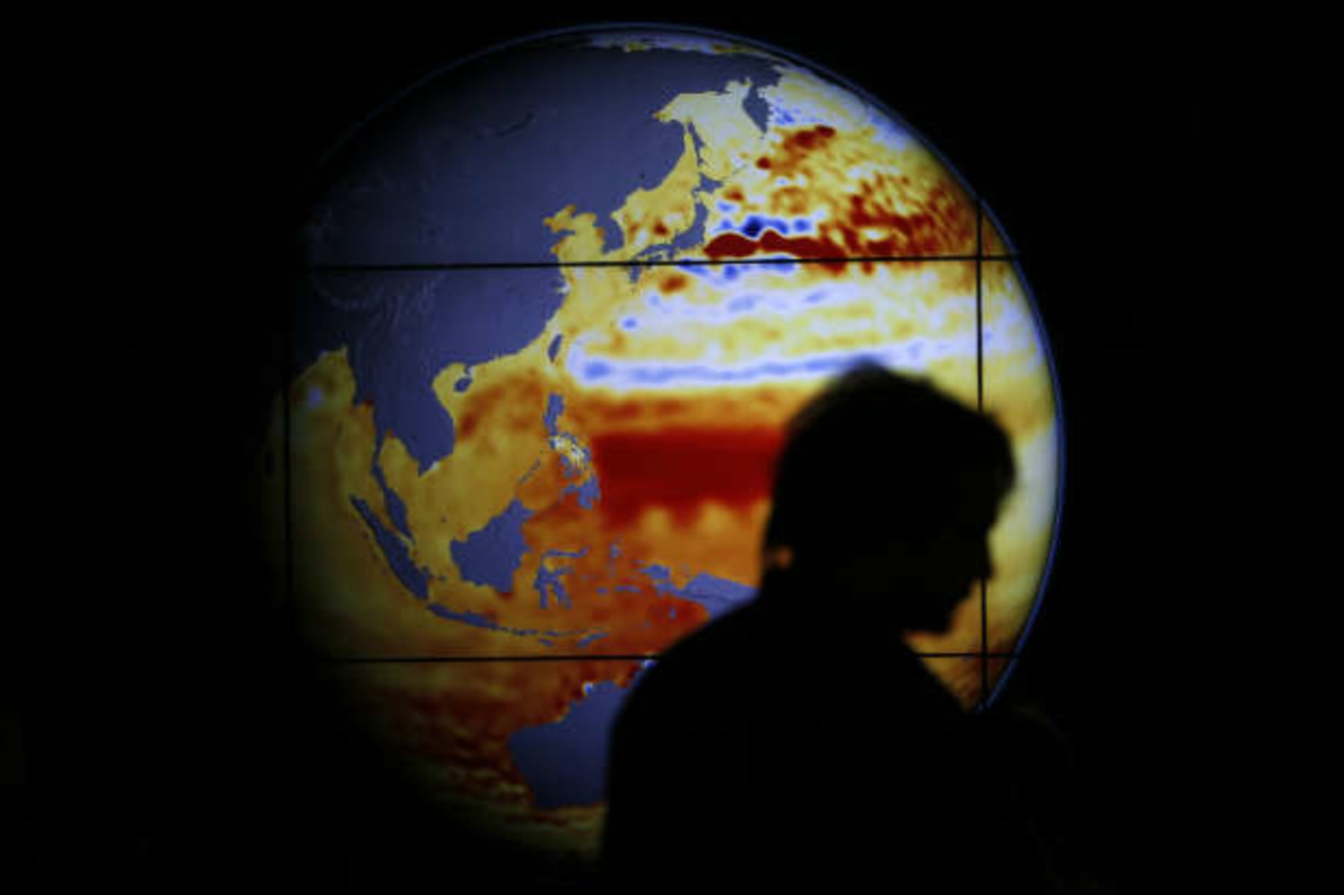 <p>A woman walks past a map showing the elevation of the sea in the last 22 years during the 2015 World Climate Change Conference. (Stephane Mahe/Courtesy Reuters)</p>
