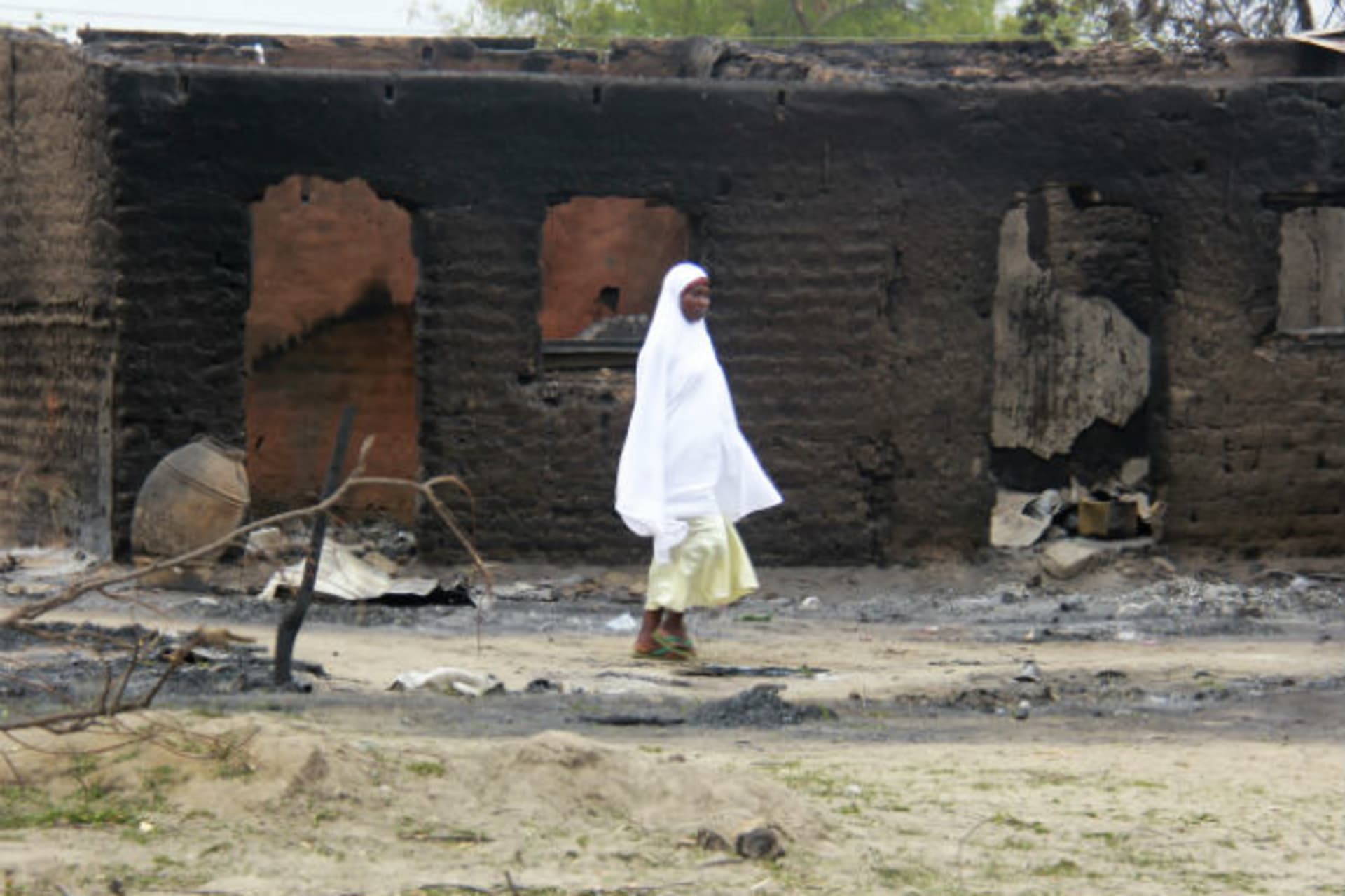 A woman walks past burnt houses in the aftermath of what Nigerian authorities said was heavy fighting between security forces and Islamist militants in Baga, a fishing town on the shores of Lake Chad, adjacent to the Chadian border, April 21, 2
