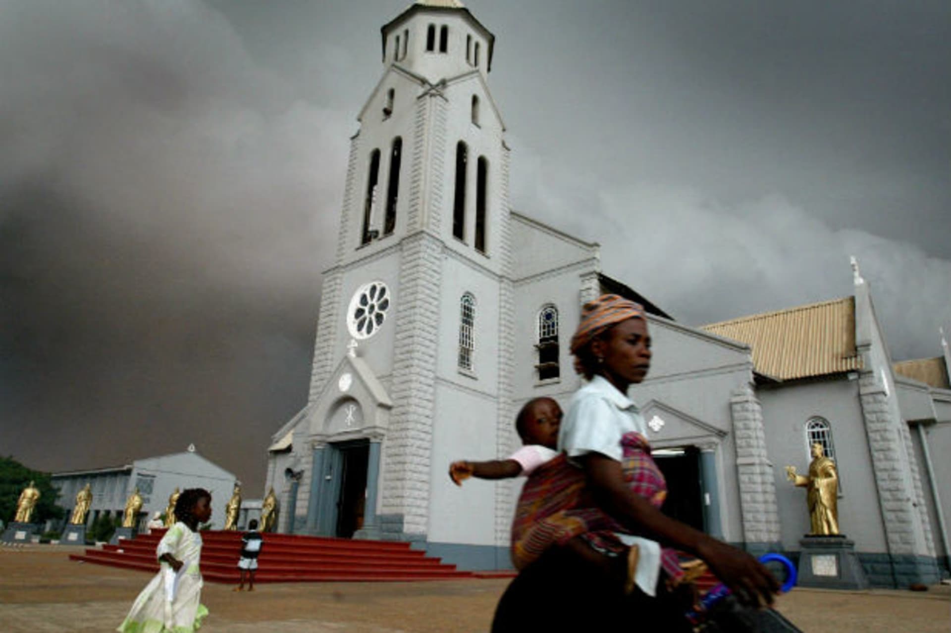 Storm clouds gather over the Church of the Holy Trinity in Onitsha, Nigeria, April 14, 2005.