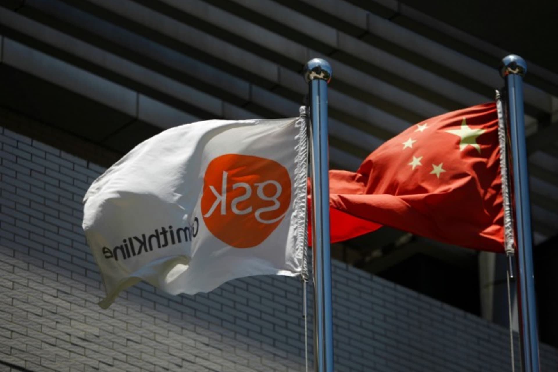 <p>A flag (L) bearing the logo of GlaxoSmithKline (GSK) flutters next to a Chinese national flag outside a GlaxoSmithKline office…nfessed to bribery and tax violations during one of a string of investigations into foreign firms. (Aly Song/Courtesy Reuters)</p>

