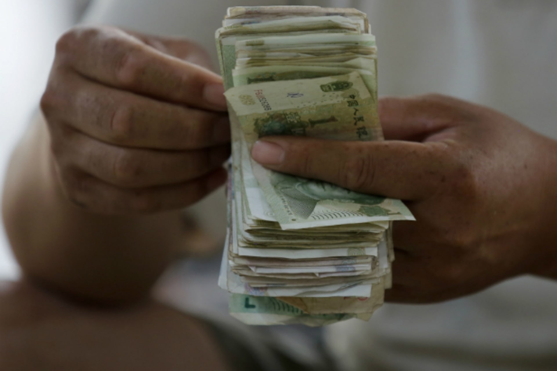 <p>A vendor counts Chinese Yuan banknotes at a market in Beijing on August 9, 2013. China’s consumer inflation steadied in July although factory-gate deflation persisted for a 17th month, official data showed on Friday. (Kim Kyung Hoon/Courtesy Reuters)</p>
