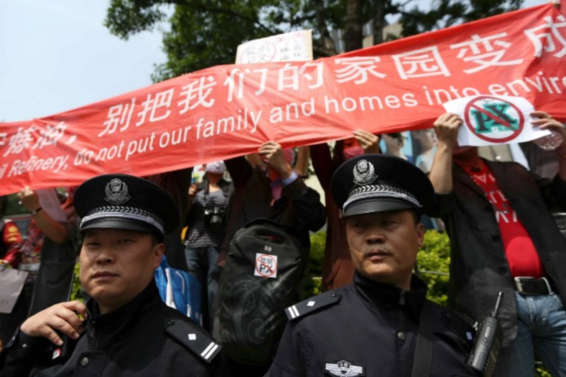 <p>Police officers stand guard as residents raise a banner to protest against a planned refinery in Kunming, Yunnan province, on May 4, 2013.</p>
