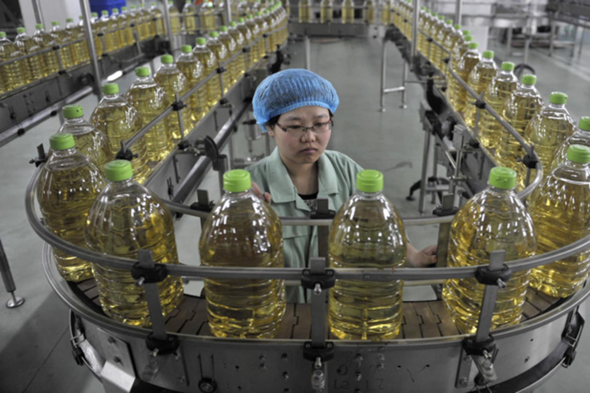 <p>An employee works at the production line of an edible oil company in Sanhe, Hebei April 12, 2011.</p>
