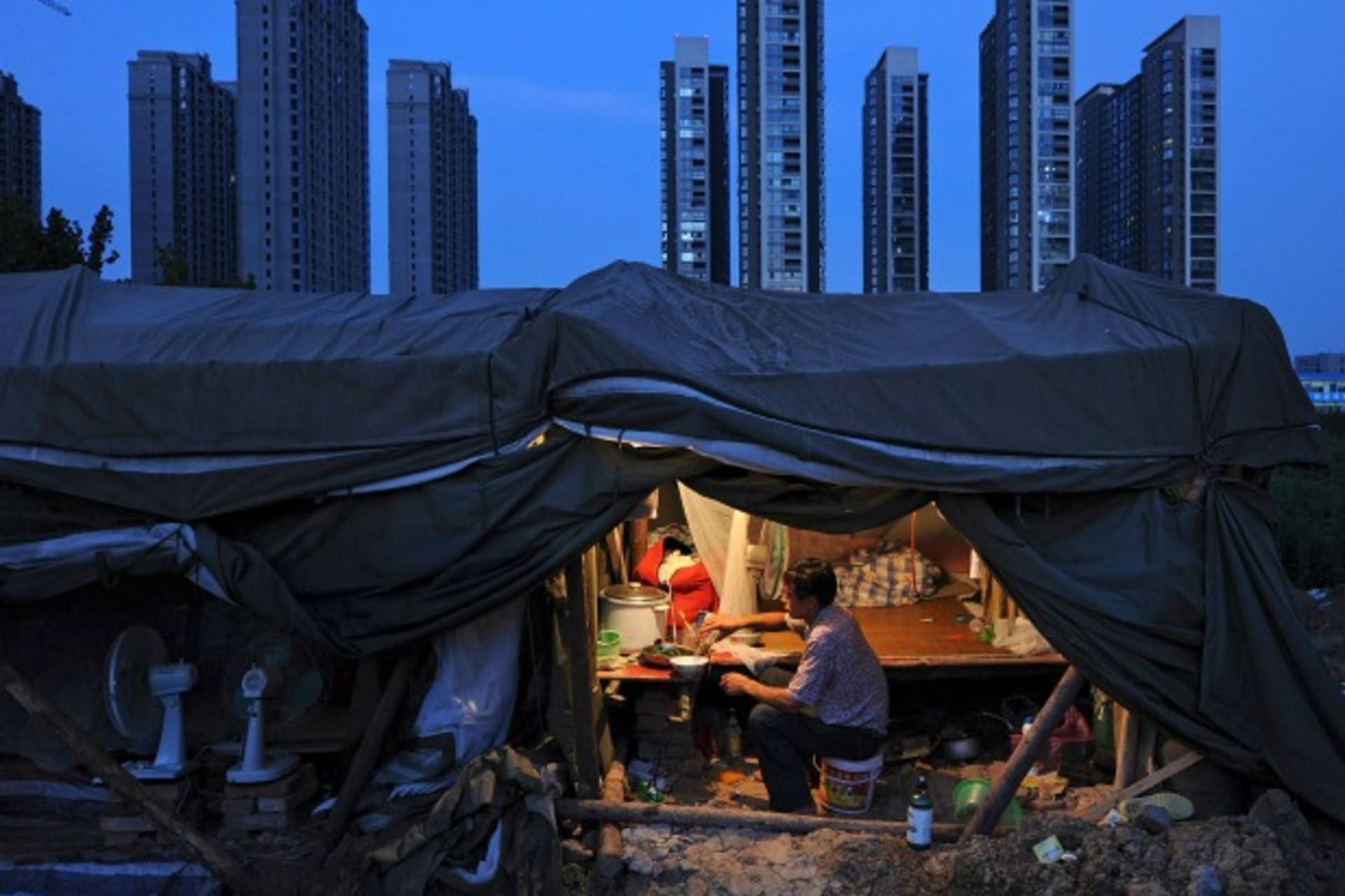 <p>A labourer has his dinner under his shed at a construction site of a residential complex in Hefei, Anhui province, August 1, 2012. (Stringer/Courtesy Reuters)</p>