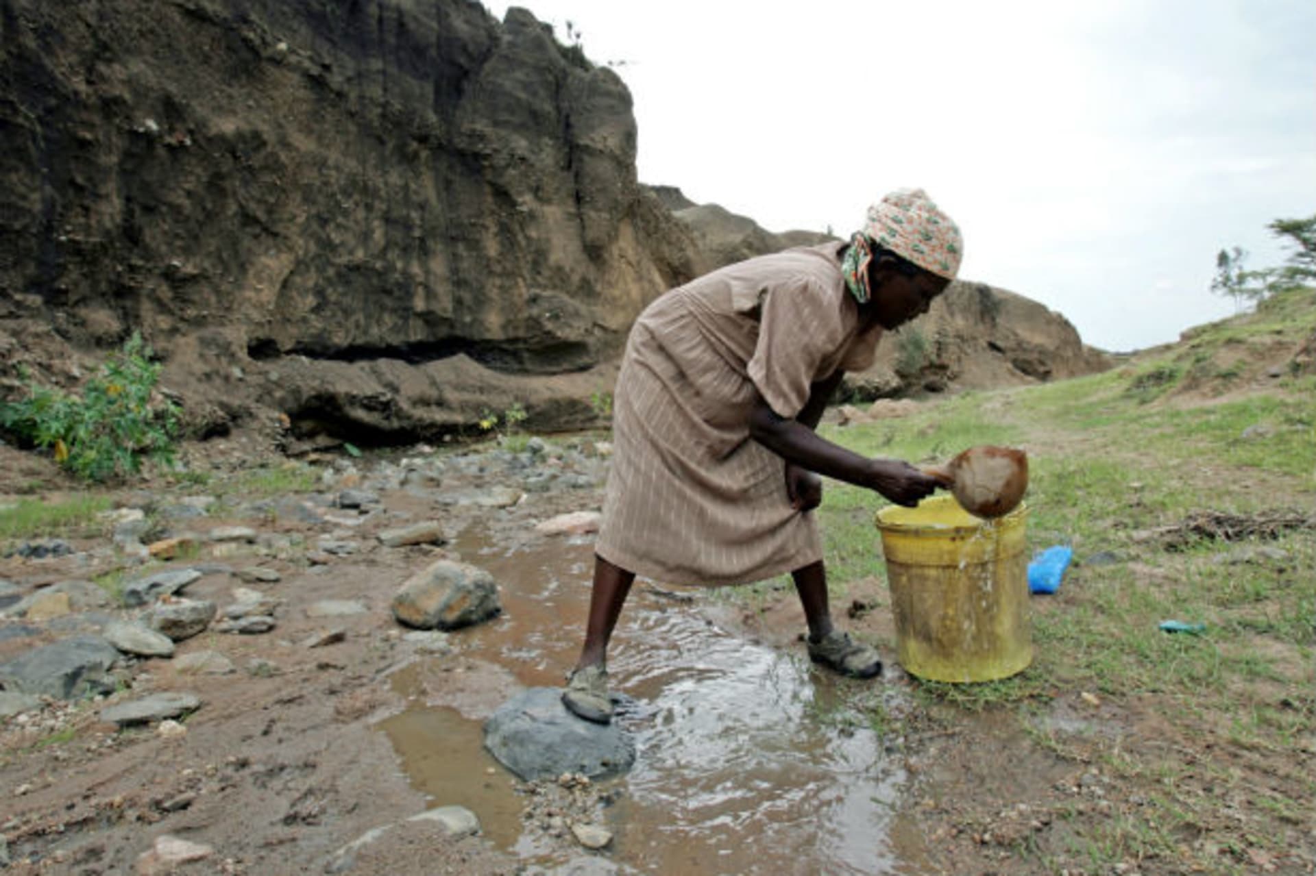 A Kenyan woman fetches water from a gully in Nyakach district, an area where massive land degradation has been exacerbated by livestock grazing and a rapidly increasing population, in western Kenya June 28, 2005.