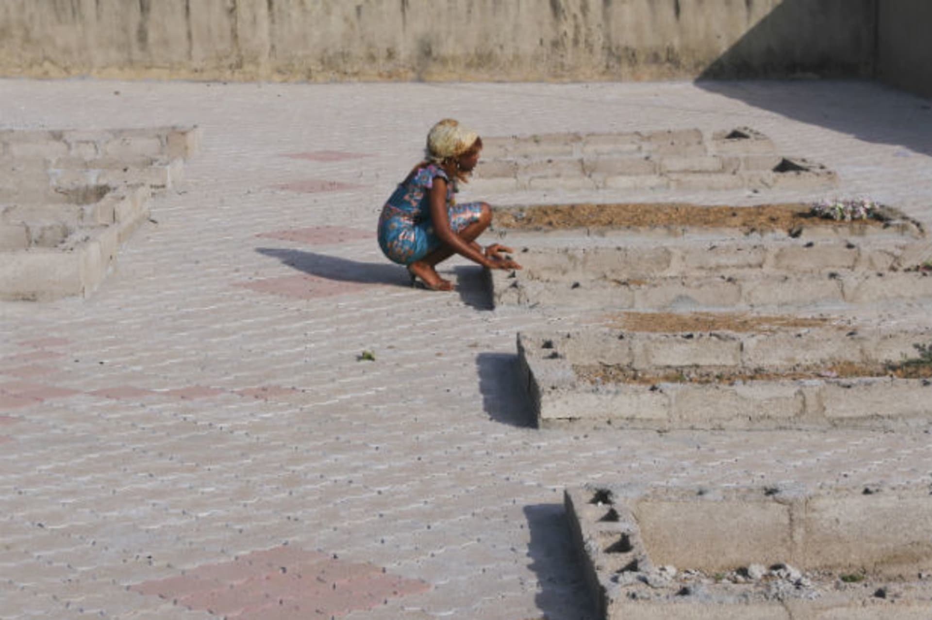 A girl kneels near the graves of victims of a suicide bomb attack at St. Theresa's Church in Madalla, on the outskirts of Nigeria's capital Abuja 24/12/2012.