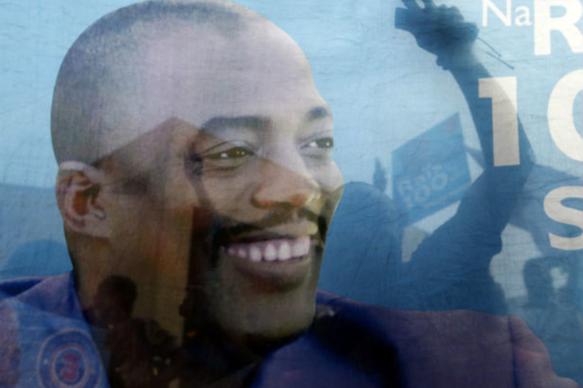 Supporters of incumbent President Joseph Kabila are seen celebrating through a banner with his image after provisional election results are announced in Democratic Republic of Congo's capital Kinshasa, December 9, 2011.