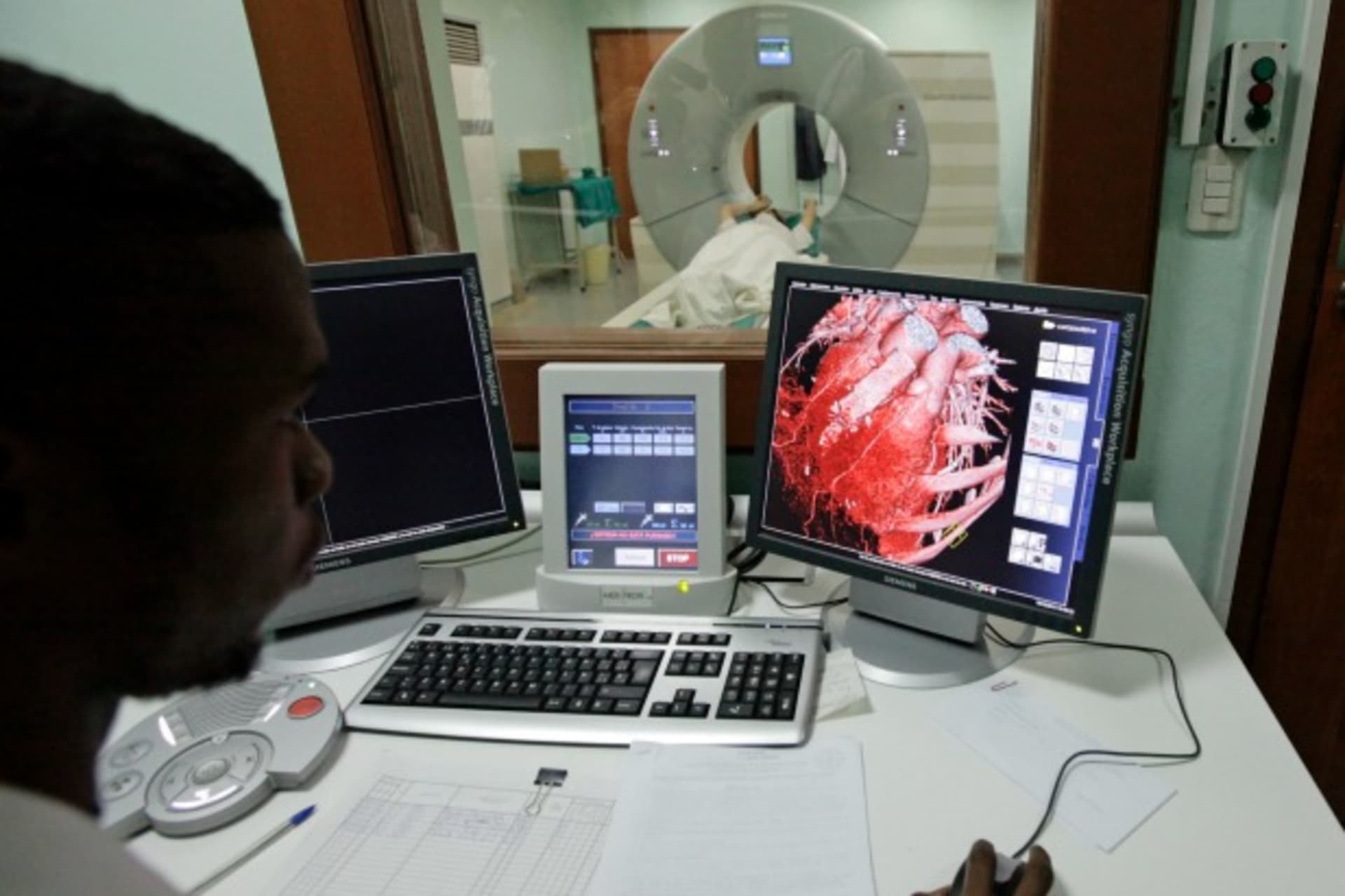 <p>A doctor observes a screen showing a graphical representation of the heart of a woman undergoing a whole-body scan. (Desmond Boylan/Reuters)</p>
