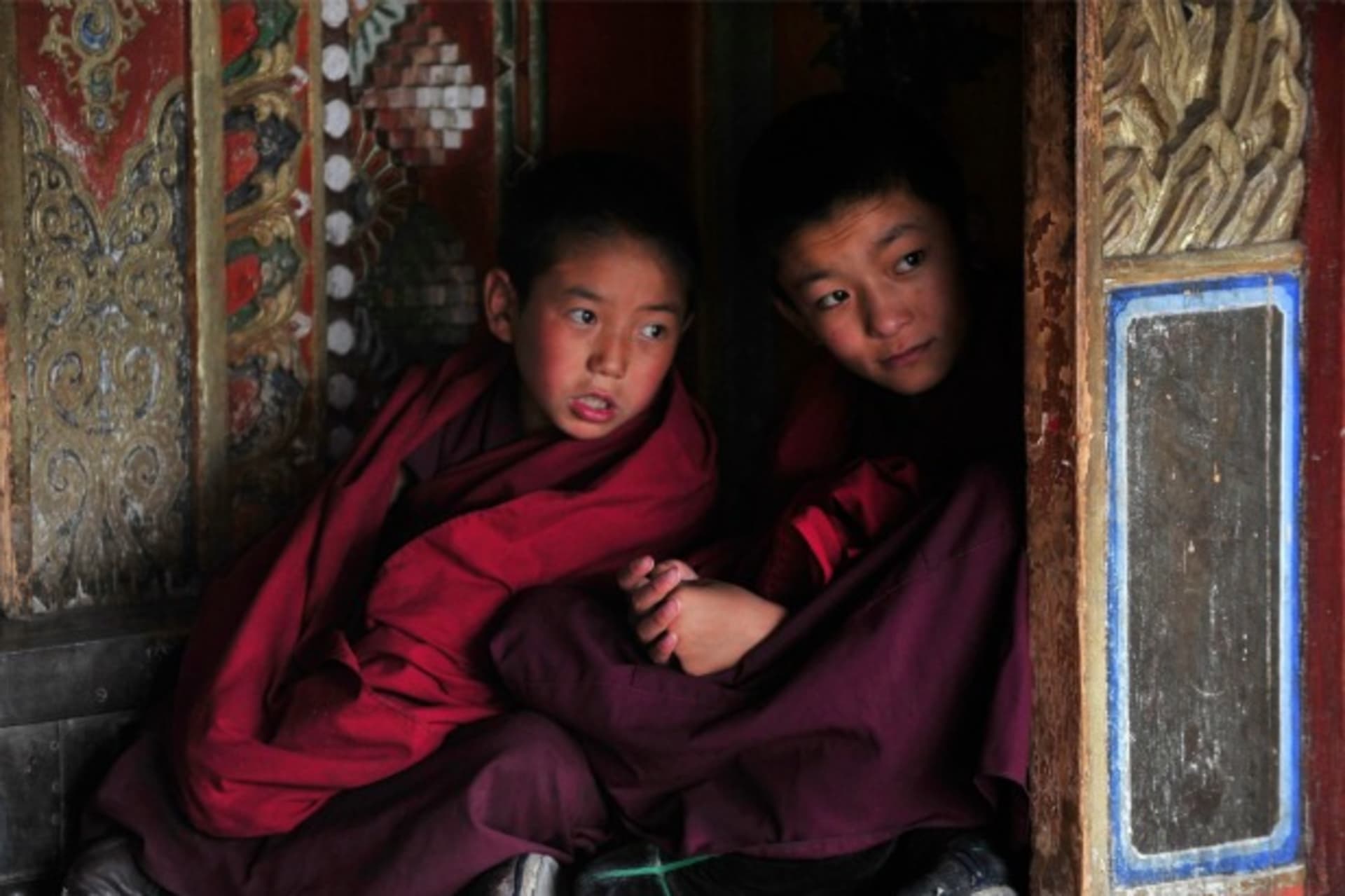 Young Tibetan monks chat during a prayer meeting for tourists at a temple in Huangnan Tibetan Autonomous Prefecture, Qinghai province on July 19, 2012.