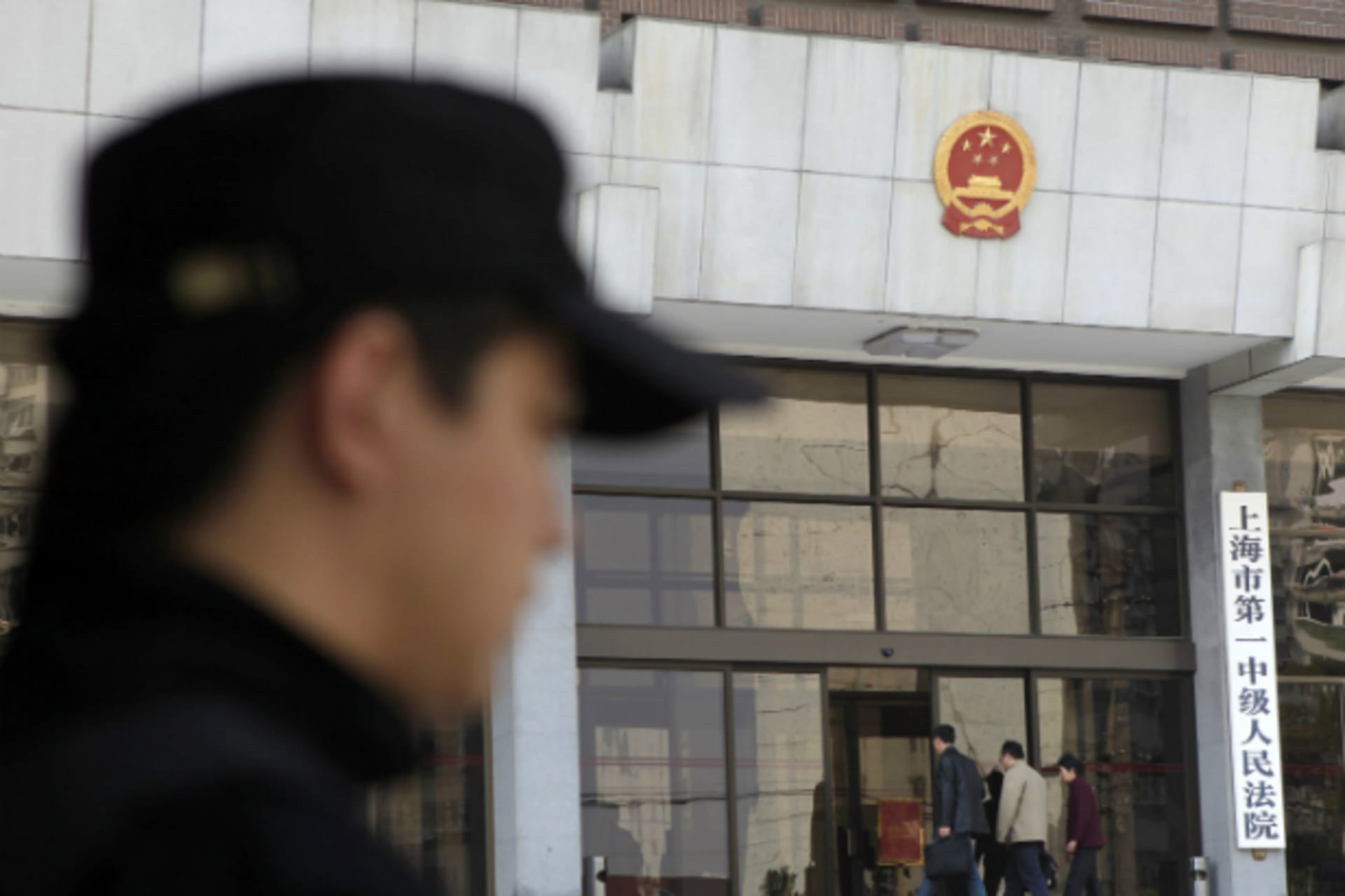 <p>A security personnel stands guard at the Shanghai’s No. 1 People’s Intermediate Court. (Aly Song/Courtesy Reuters)</p>
