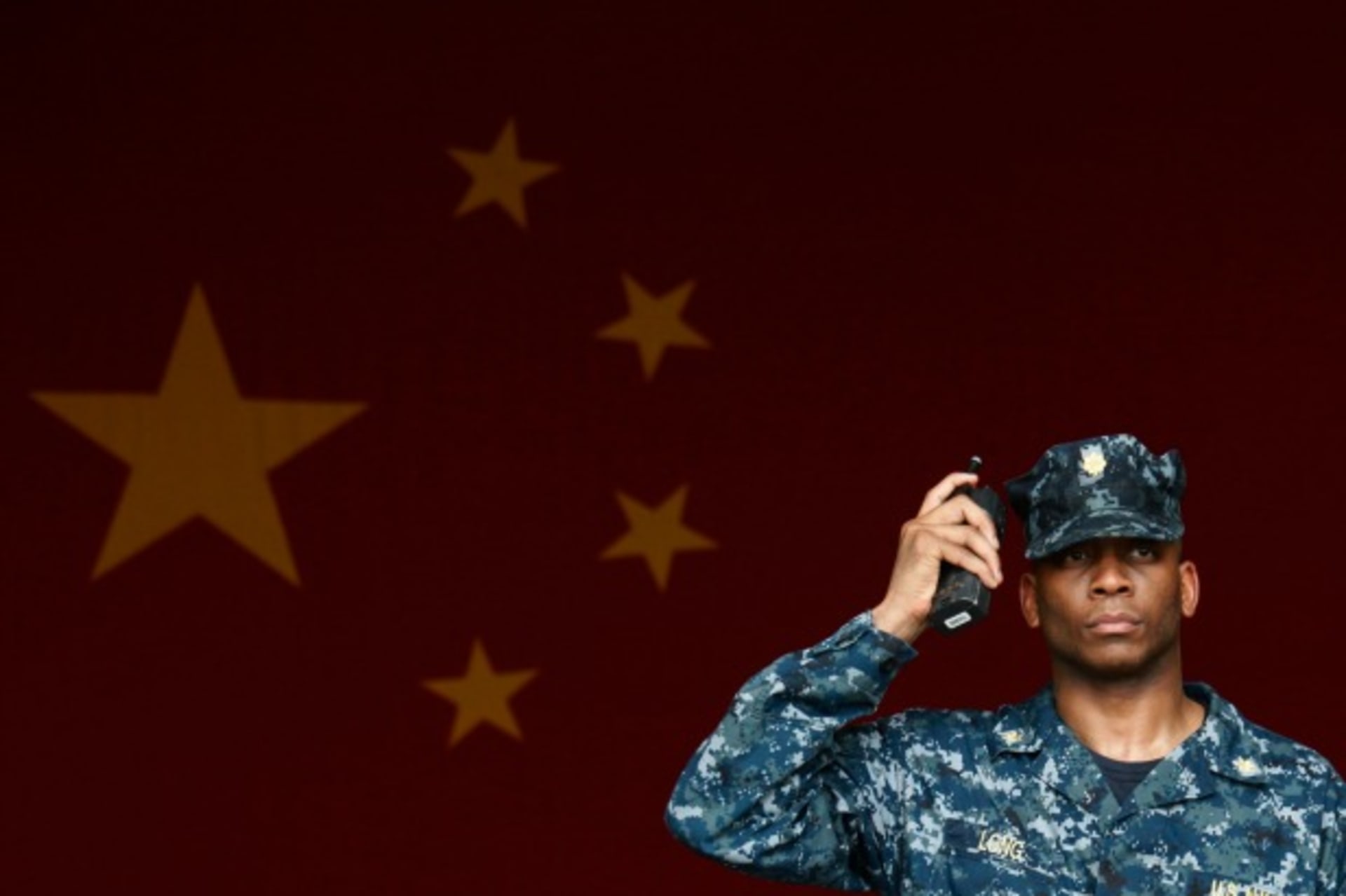 <p>A U.S. Navy servicemen listens to a walkie-talkie in front of a Chinese national flag onboard U.S. aircraft carrier USS George…ngton during its port call in the Hong Kong waters June 16, 2014. REUTERS/Bobby Yip (CHINA – Tags: MILITARY POLITICS MARITIME)</p>

