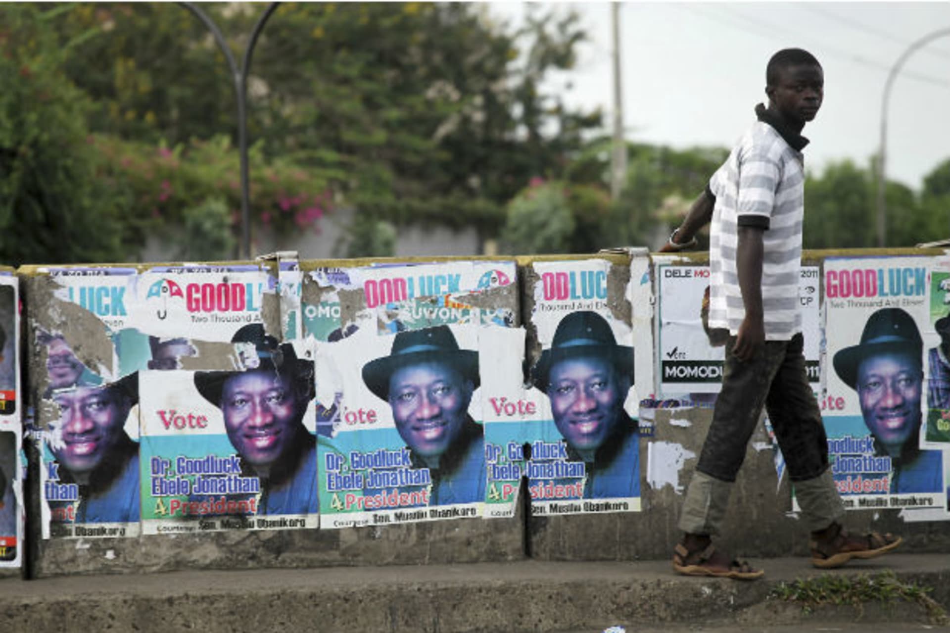 A man walks past election posters for Nigeria's President Goodluck Jonathan in the Maryland district of the commercial capital Lagos April 16, 2011.