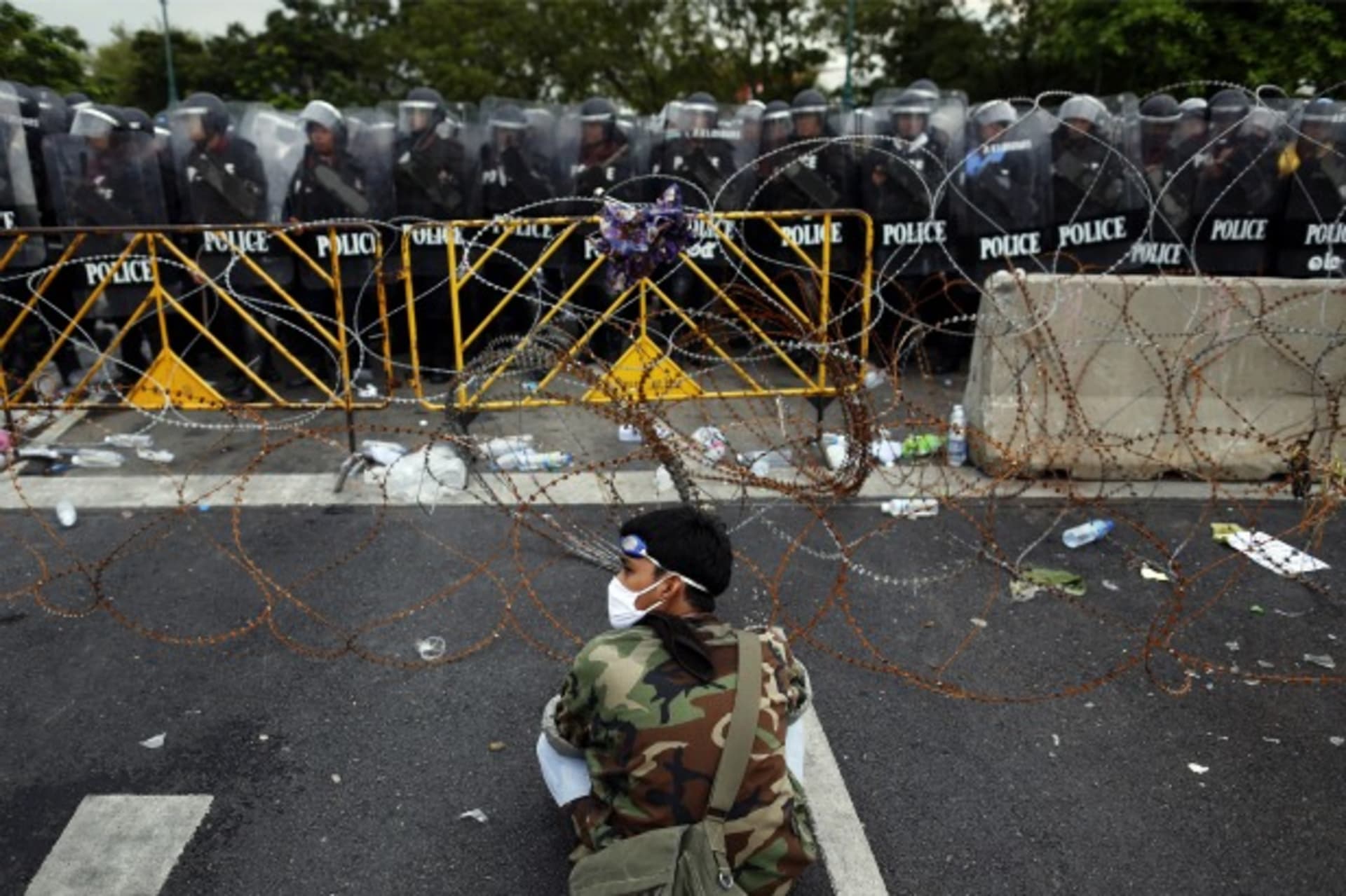 <p>An anti-government protester sits in front of riot police near the Government house in Bangkok on November 24, 2012.</p>
