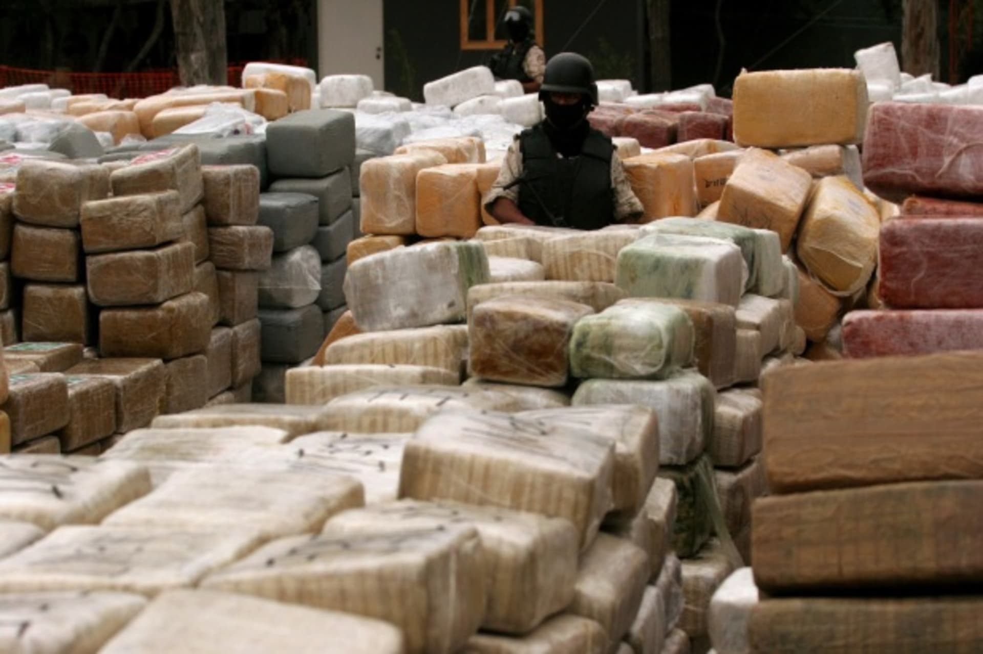 <p>Soldiers stand guard next to narcotics wrapped in ten thousand brown and silver packages on display in Tijuana (Jorge Duenes/Courtesy Reuters).</p>
