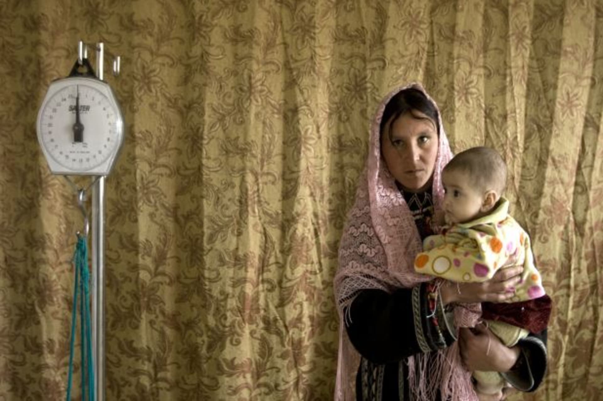 <p>A mother holds her child as she visits a health clinic in Eshkashem district of Badakhshan province in Afghanistan (Ahmad Masood/Courtesy Reuters).</p>
