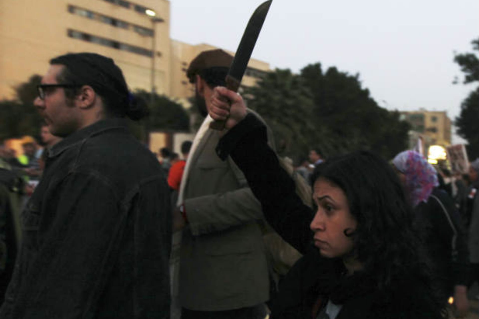 A woman raises a knife against Egyptian president Mohammed Morsi and members of the Brotherhood during a march against sexual harassment and violence against women in Cairo February 6, 2013 (Dalsh/Courtesy Reuters)..