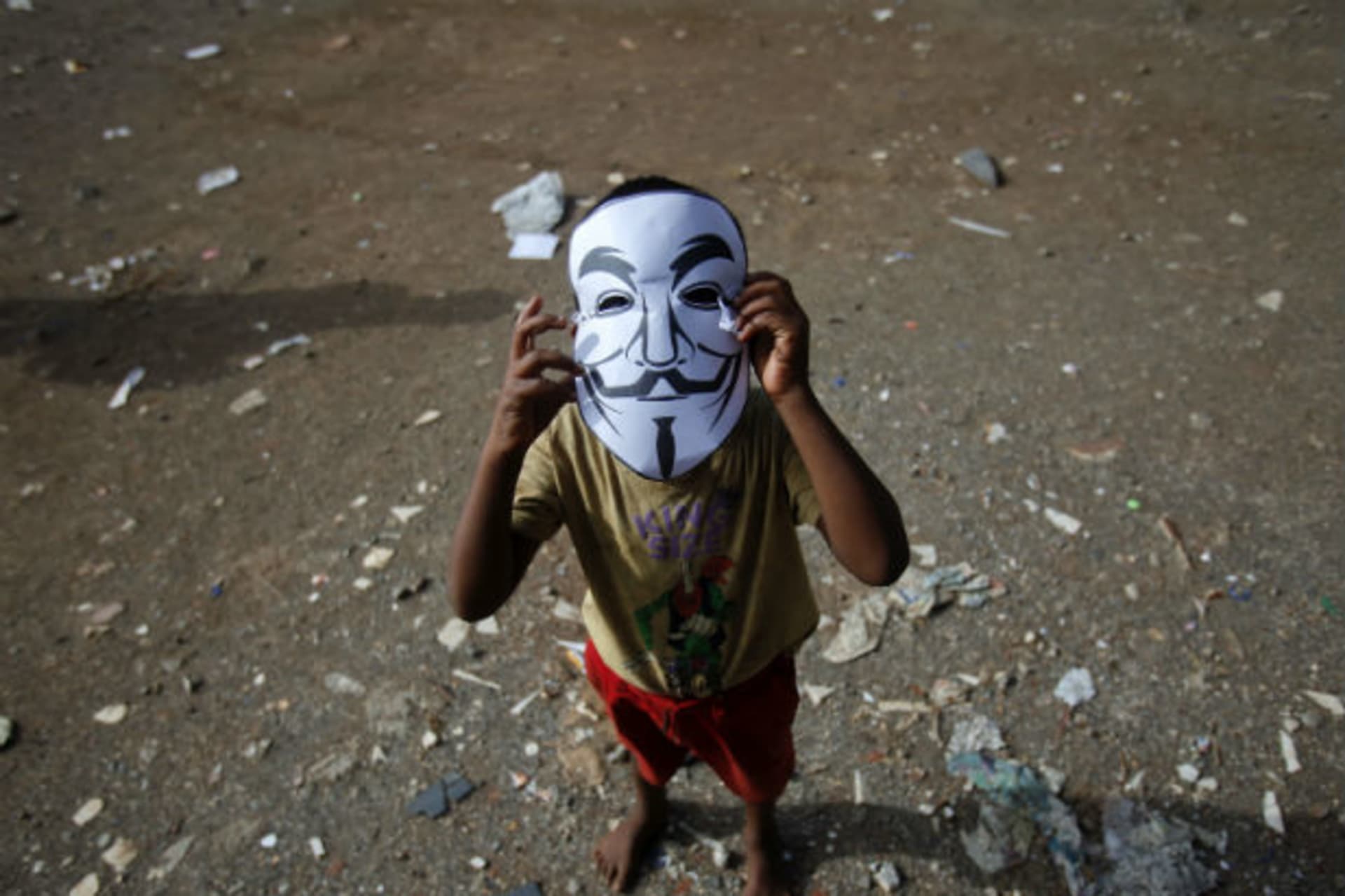 A child wears a paper mask depicting Guy Fawkes during a protest by Anonymous India against laws they say gives the government control over censorship of Internet usage in Mumbai, June 9, 2012.