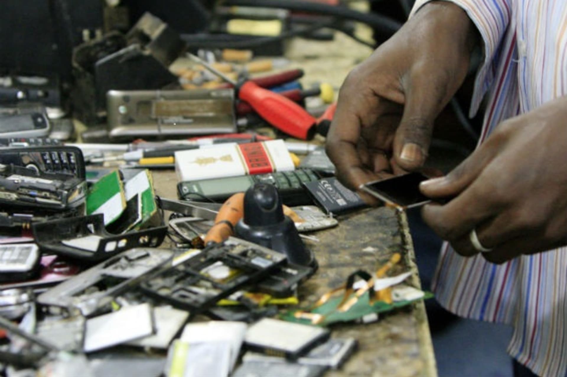 A technician repairs cell phones in his store in Khartoum December 21, 2011.