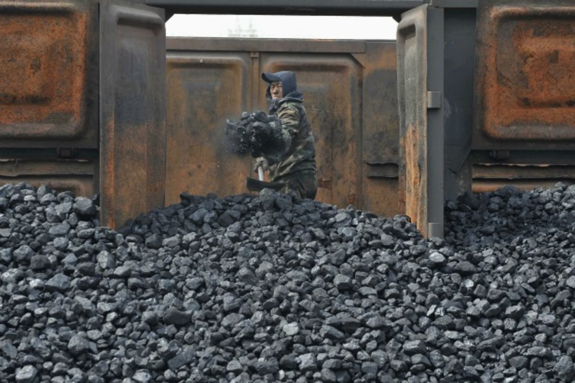 <p>A worker unloads coal at a storage site along a railway station in Shenyang, Liaoning province on April 13, 2010.</p>
