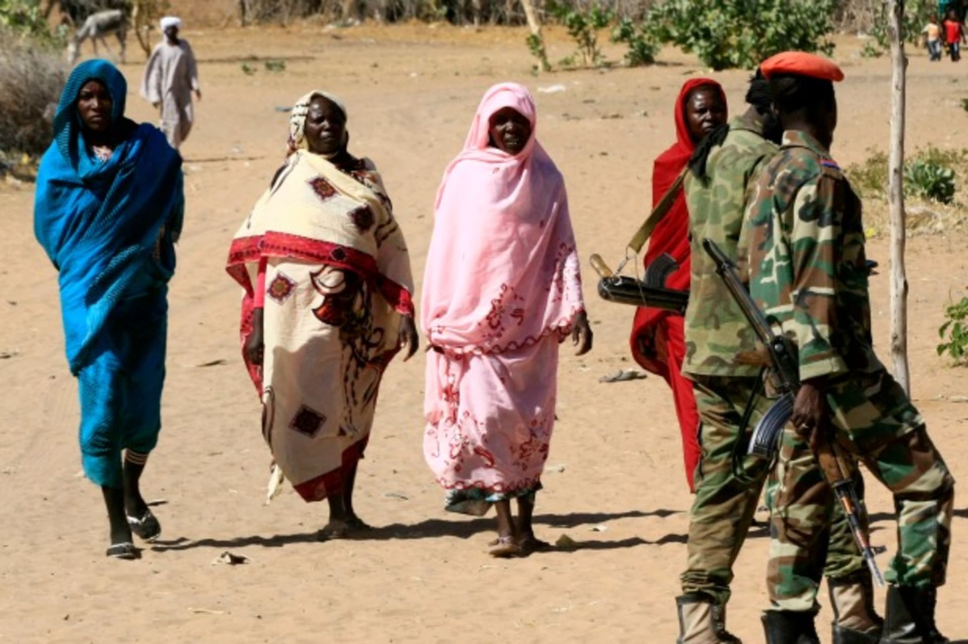 <p>Military personnel walk past women in Tabit village in North Darfur, Sudan. The joint peacekeeping mission in the region known…2014 to investigate media reports of an alleged mass rape of 200 women and girls (Courtesy Mohamed Nureldin Abdallah/Reuters).</p>