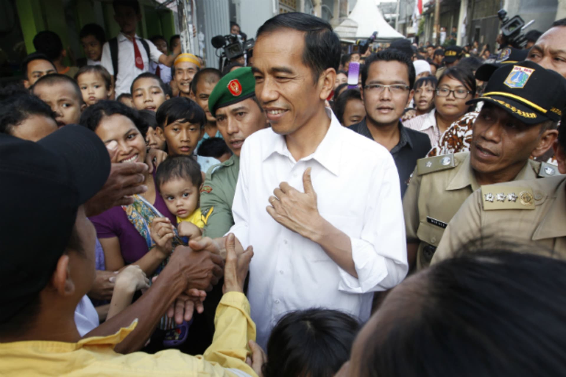 <p>Jakarta’s Governor Joko Widodo, also known as Jokowi, is surrounded by residents during his visit to inspect the aftermath of a slum fire area in west Jakarta on April 9, 2013. (Enny Nuraheni/Courtesy Reuters)</p>
