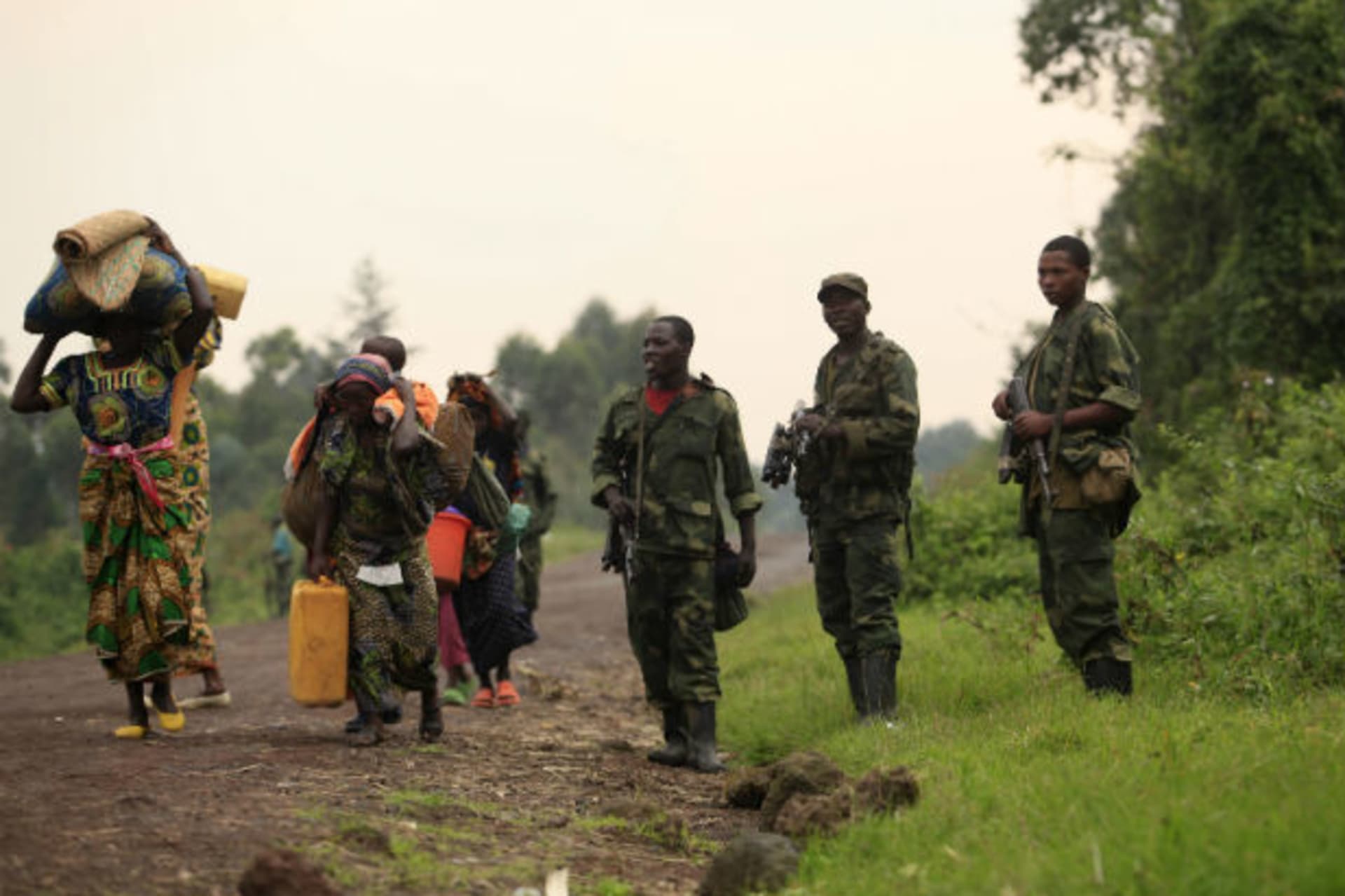 Displaced families walk past M23 rebels at Rumangabo 28/07/2012.