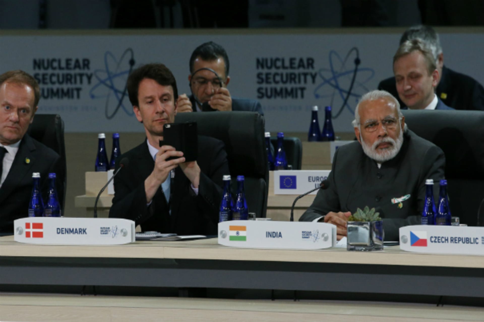 <p>A member of Denmark’s delegation (C) takes a picture with his phone while seated next to India’s Prime Minister Narenda Modi (…t the start of the second plenary session of the Nuclear Security Summit in Washington April 1, 2016 (Jonathan Ernst/Reuters).</p>
