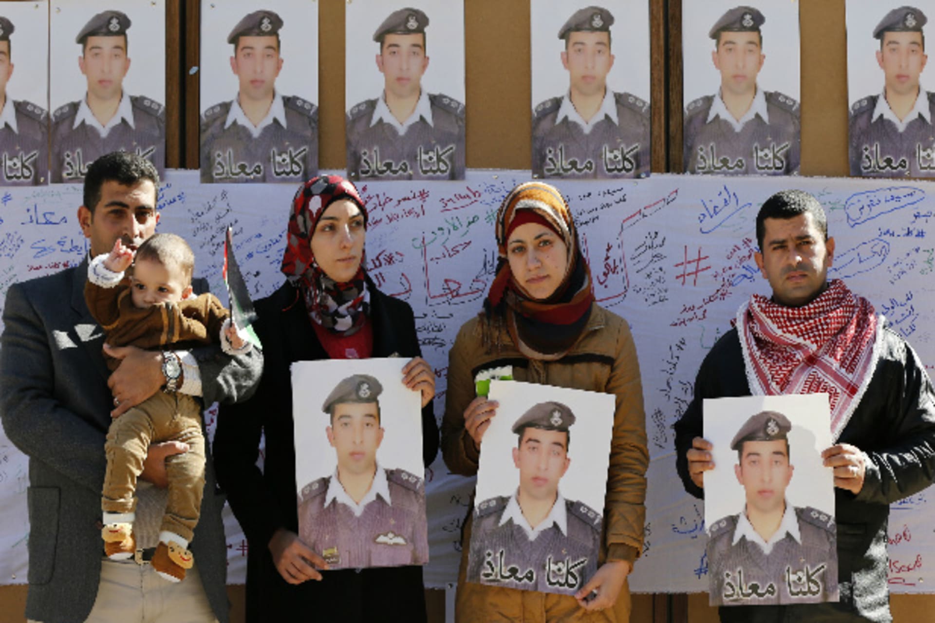 Relatives of Islamic State captive Jordanian pilot Muath al-Kasaesbeh hold pictures of him as they join students during a rally calling for his release, at Jordan University in Amman February 3, 2015 (Hamed/Courtesy Reuters).