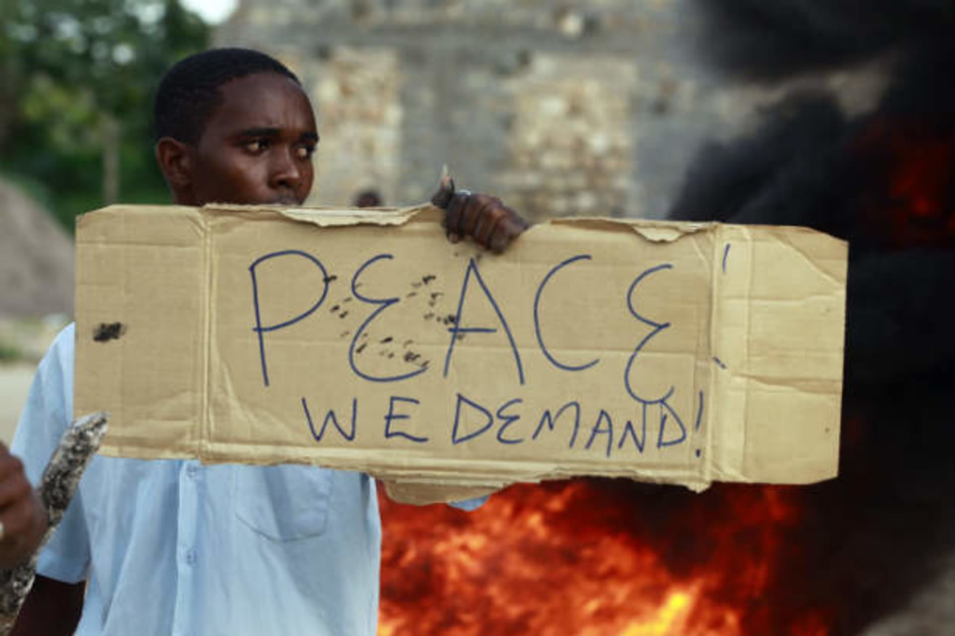 A resident holds a placard as he participates in a protest against the recent attack by unidentified gunmen in the coastal Kenyan town of Mpeketoni, June 17, 2014. (Joseph Okanga/Courtesy Reuters)