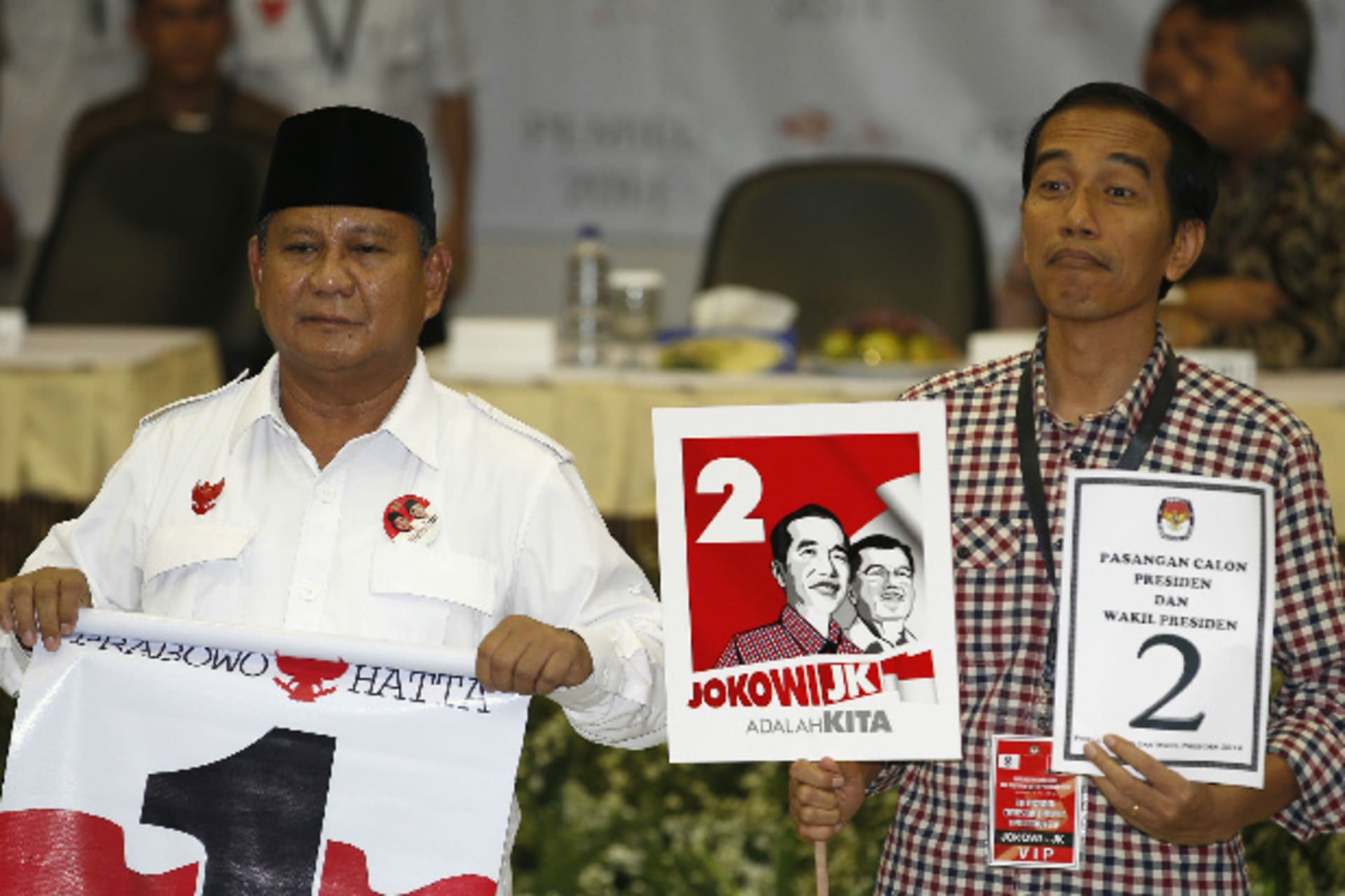 <p>Indonesian presidential candidates Prabowo Subianto (L) and Joko “Jokowi” Widodo hold their ballot numbers after drawing them at the Election Commission in Jakarta on June 1, 2014 (Stringer/Courtesy: Reuters).</p>
