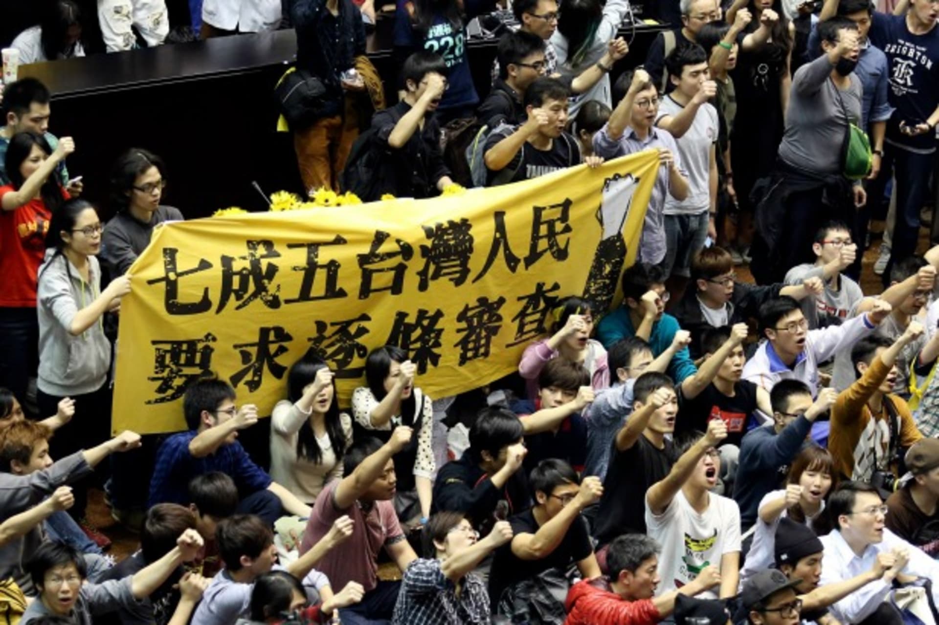 <p>Protestors in Taiwan’s legislature in Taipei hold a banner, “Seventy-five percent of Taiwanese people demand item-by-item review,” on March 19, 2014. (Patrick Lin/courtesy Reuters)</p>
