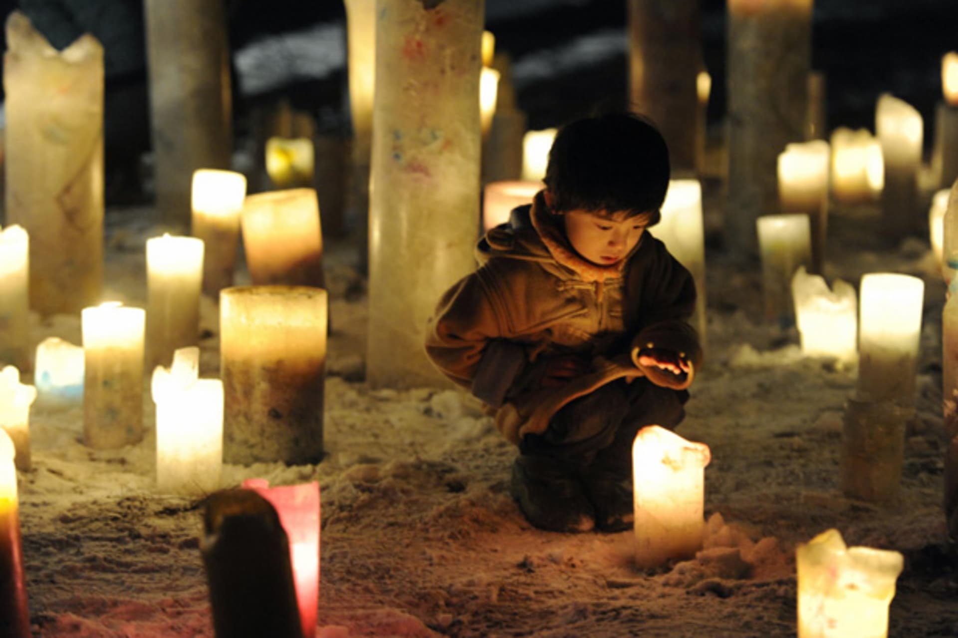 <p>A child looks at a candle flame during an event to pray for the reconstruction of areas devastated by the March 11, 2011 earthquake and tsunami, in Iwanuma in Miyagi prefecture.</p>
